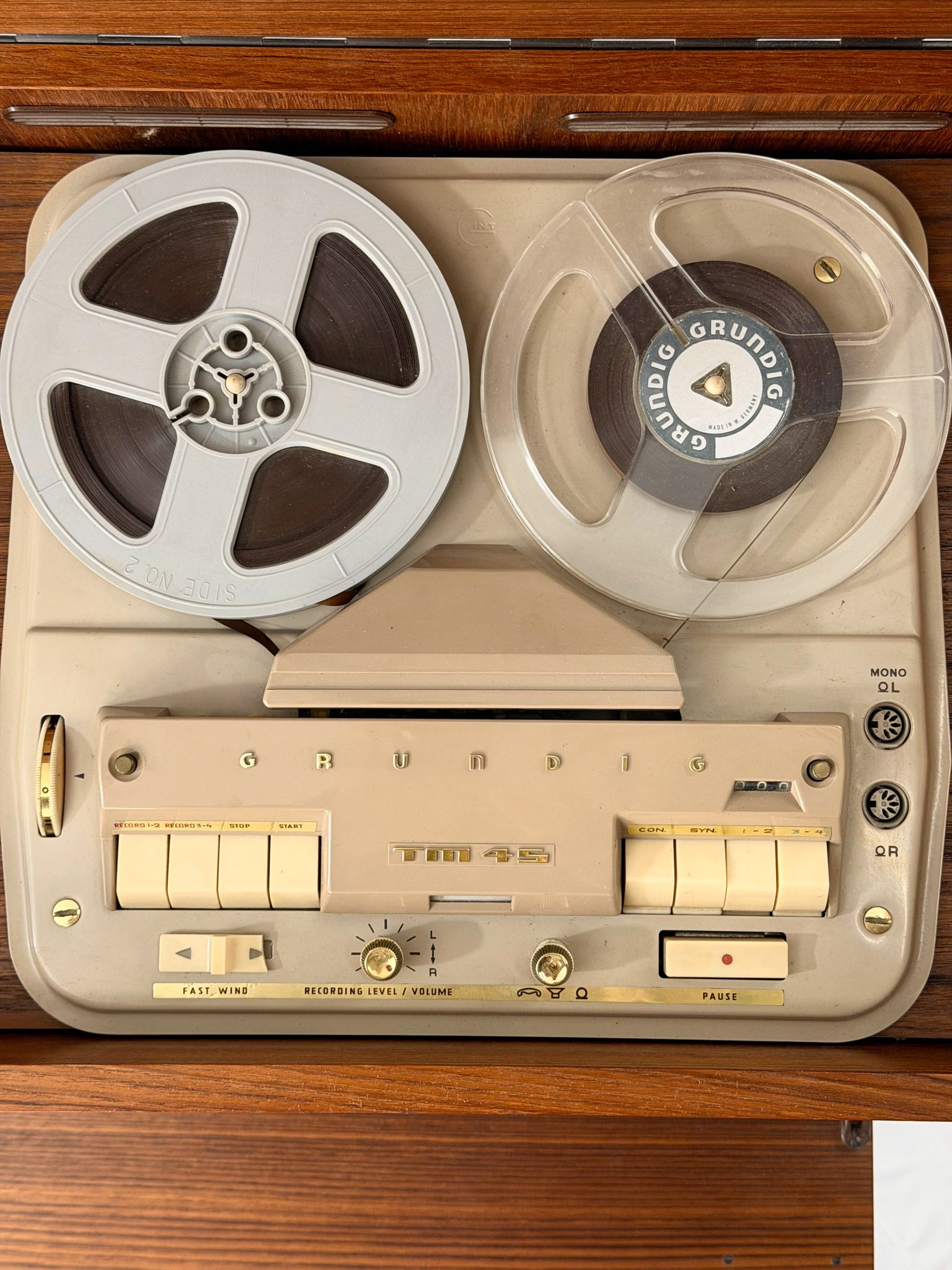 Vintage Grundig tape recorder with reel-to-reel tapes on a wooden surface