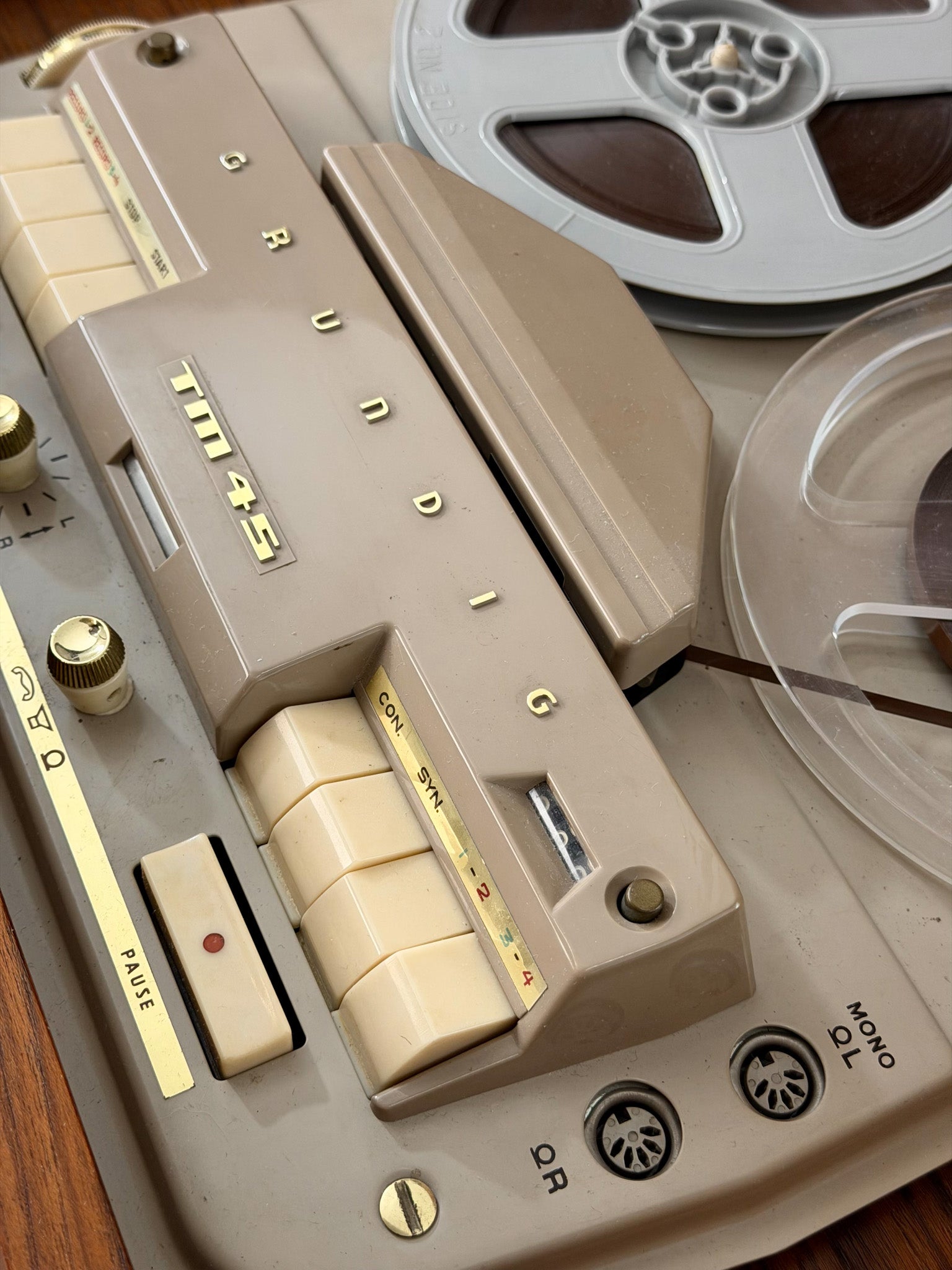Close-up of a vintage reel-to-reel tape recorder with beige and brown tones.