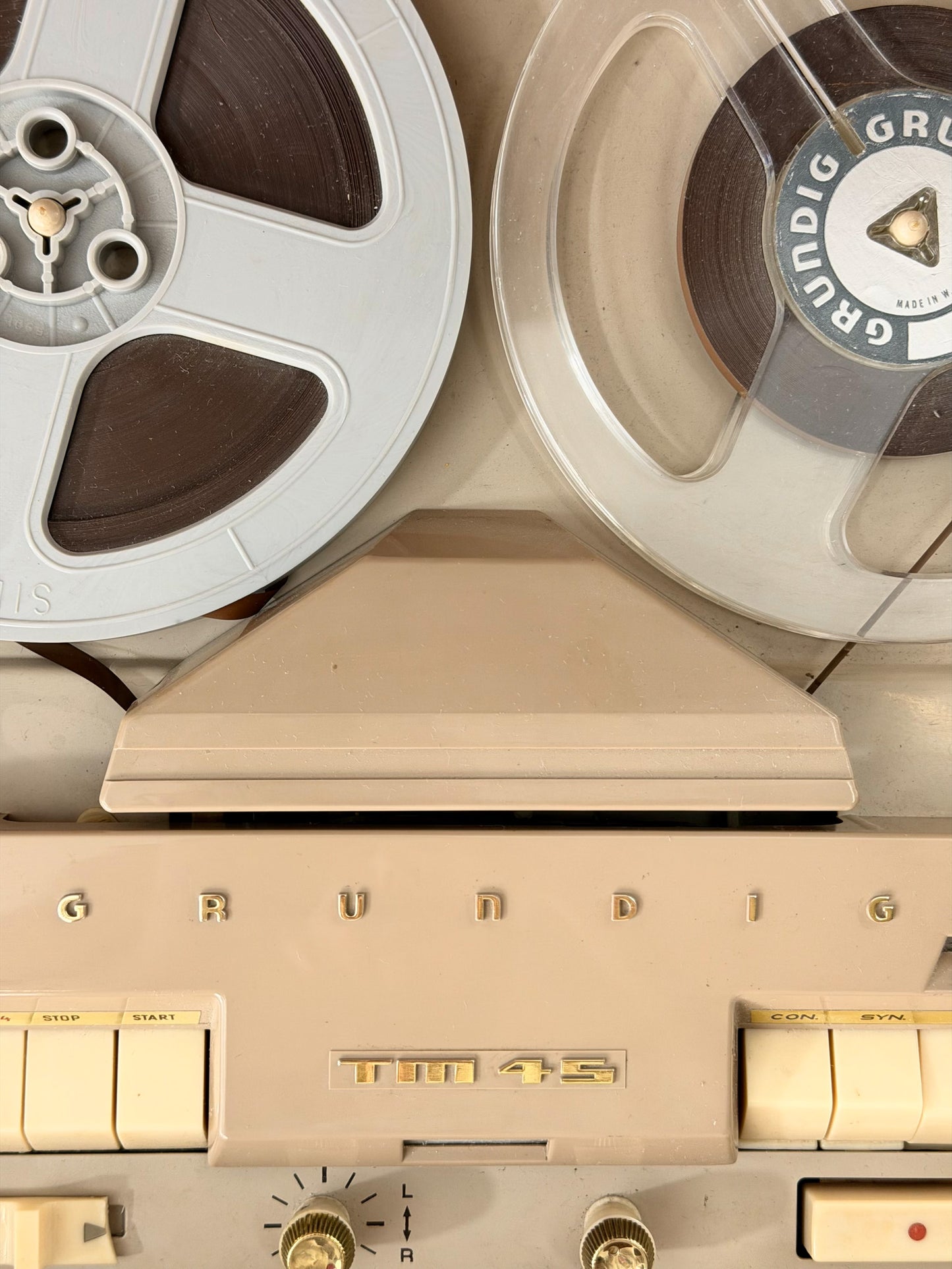 Vintage record player with a turntable and control panel on a wooden surface.