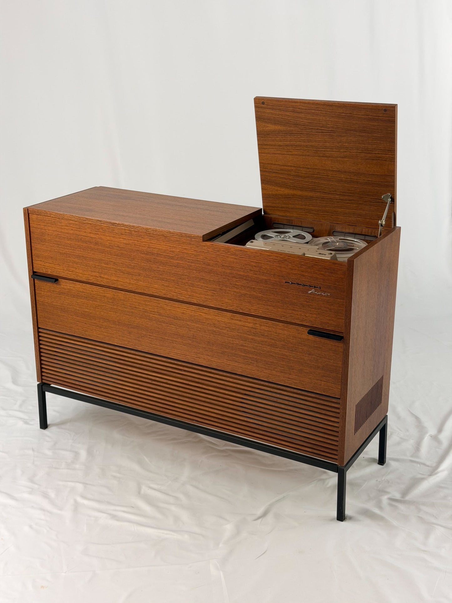 Vintage record player with a turntable and control panel on a wooden surface.