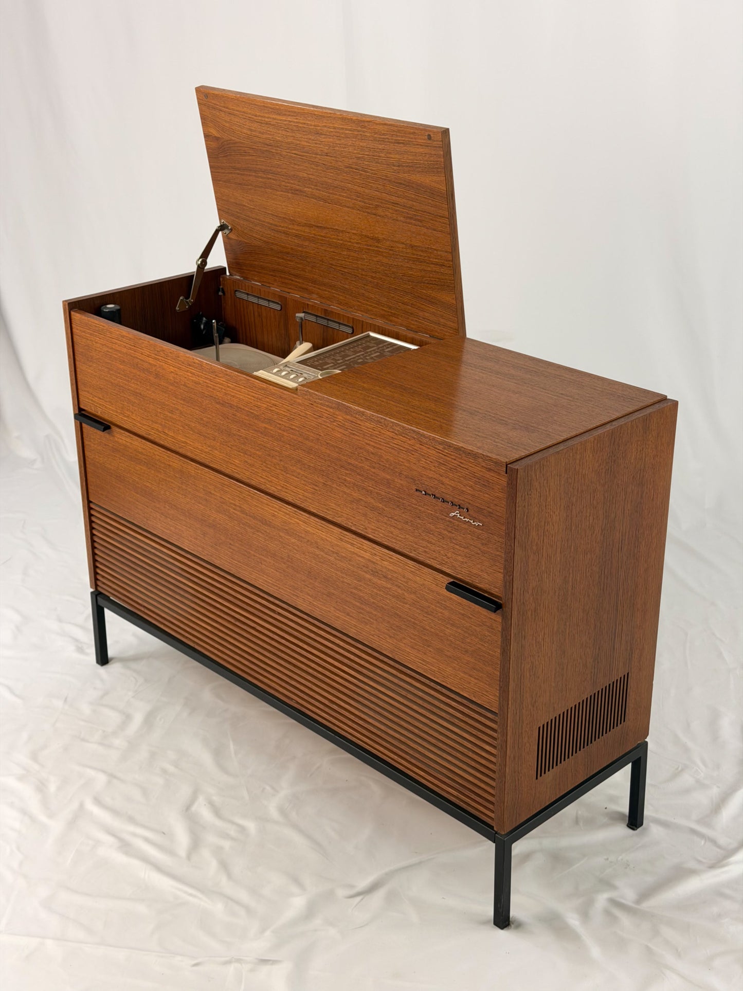 Vintage record player with a turntable and control panel on a wooden surface.
