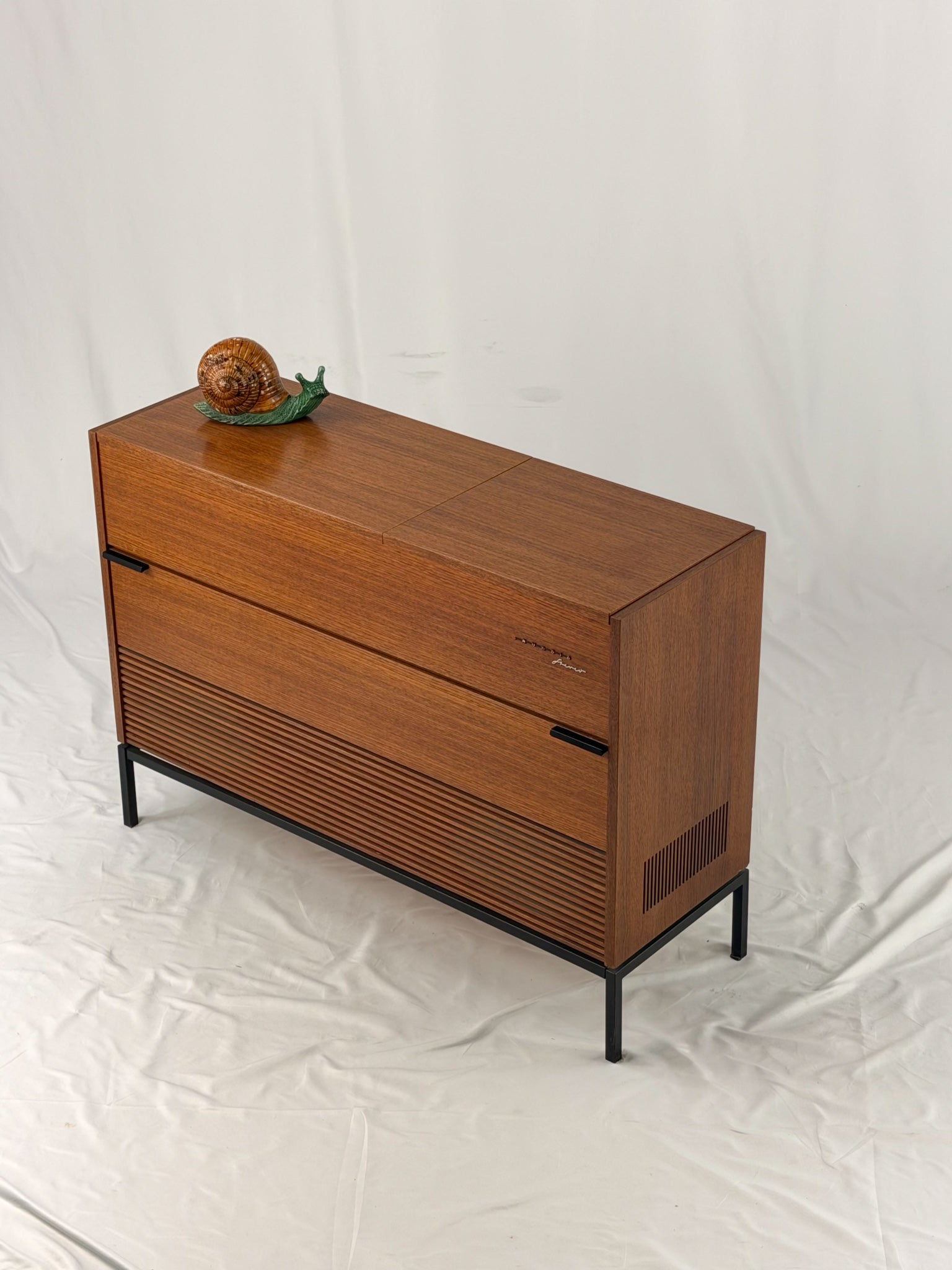 Vintage record player with a turntable and control panel on a wooden surface.