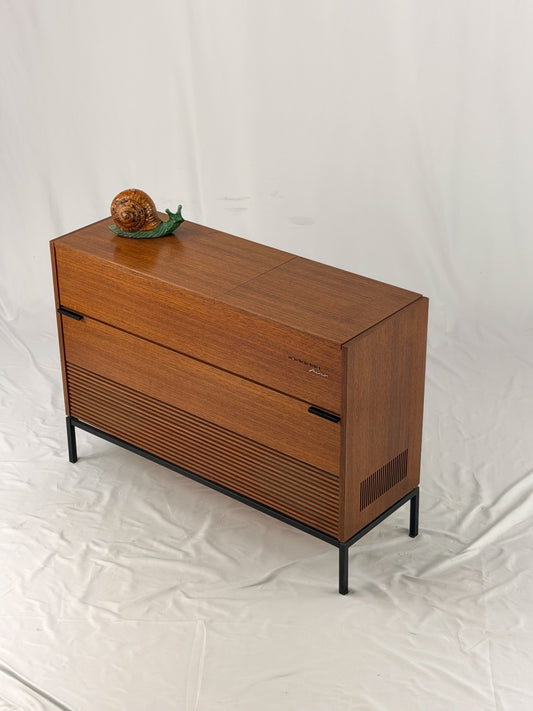 Vintage record player with a turntable and control panel on a wooden surface.