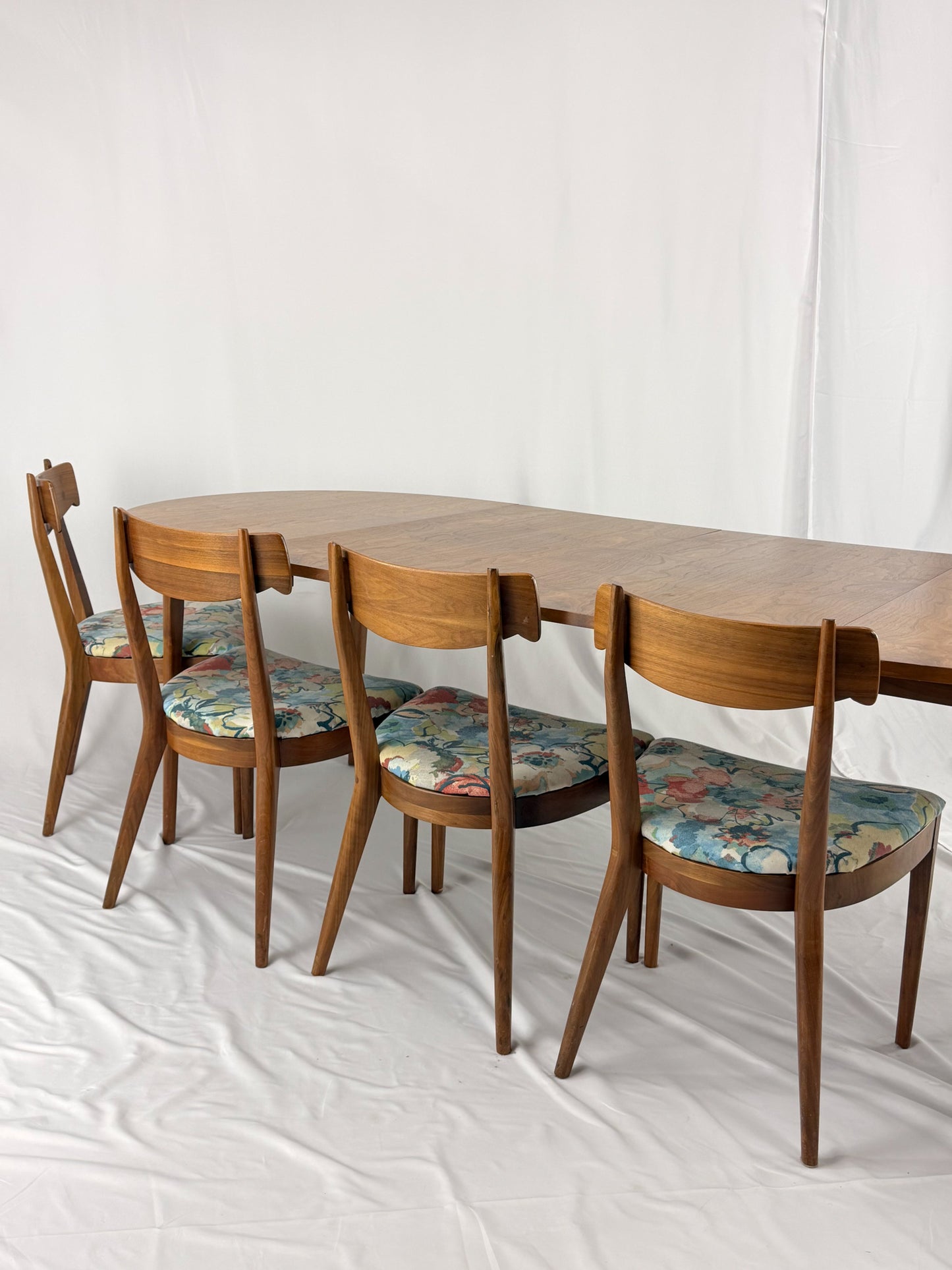 Wooden dining table with four chairs on a white background