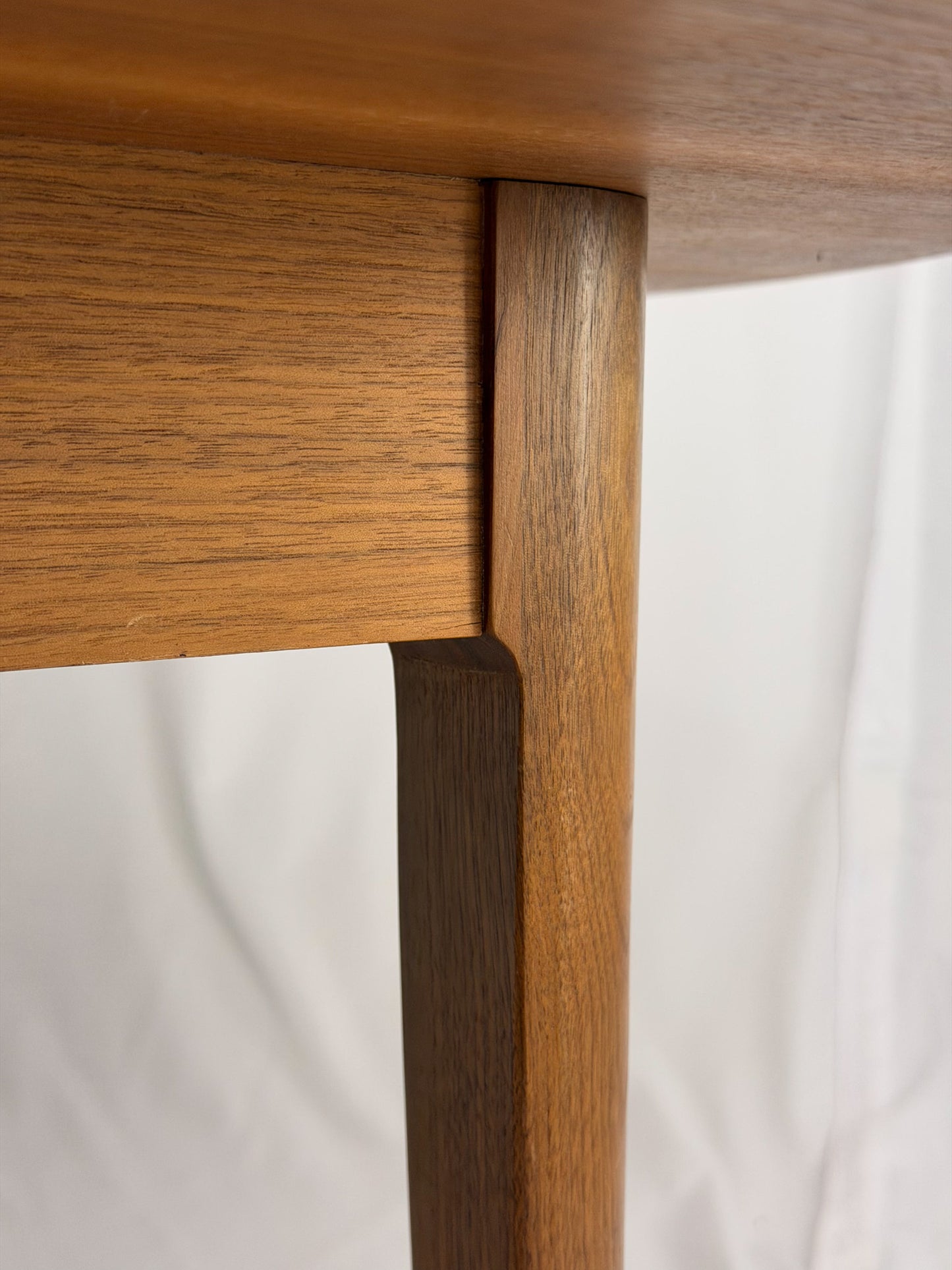 Close-up of a wooden table corner with a white background