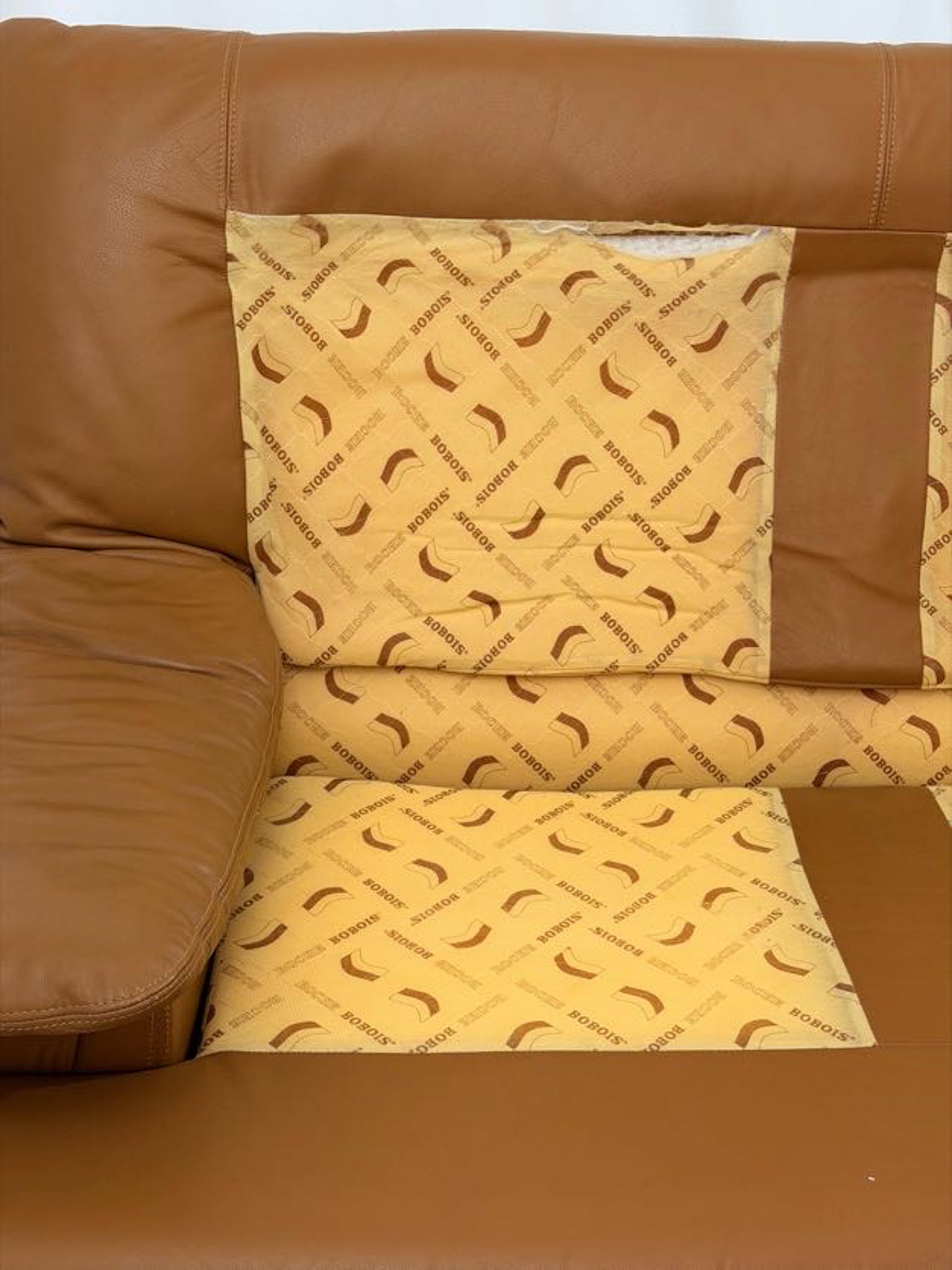 Yellow patterned cushion on a brown leather sofa