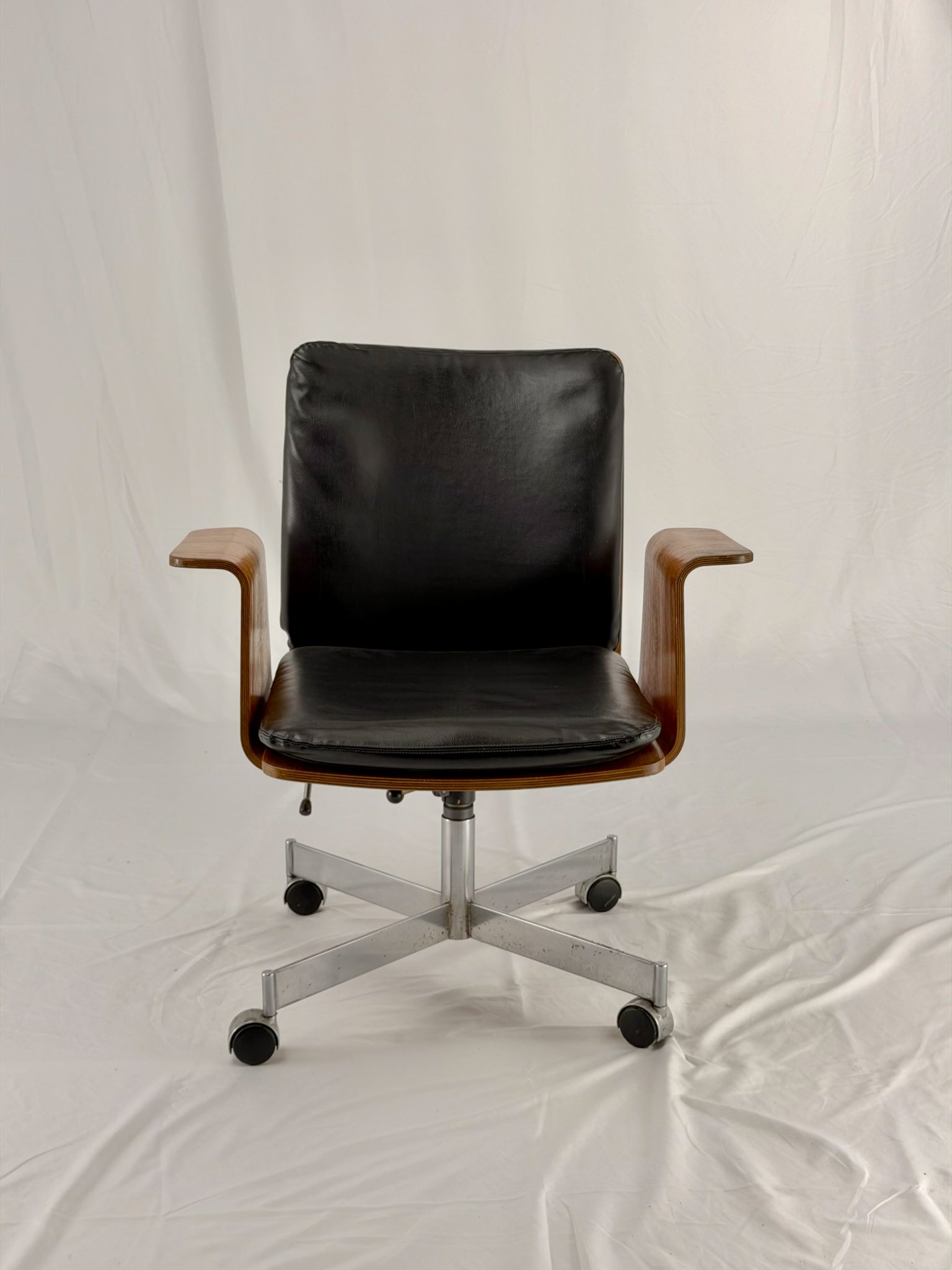 Mid Century Modern office chair with wooden frame and leather seat with a white background