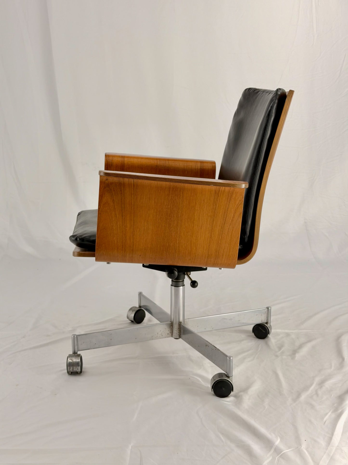 Mid Century Modern office chair with wooden frame and leather seat with a white background