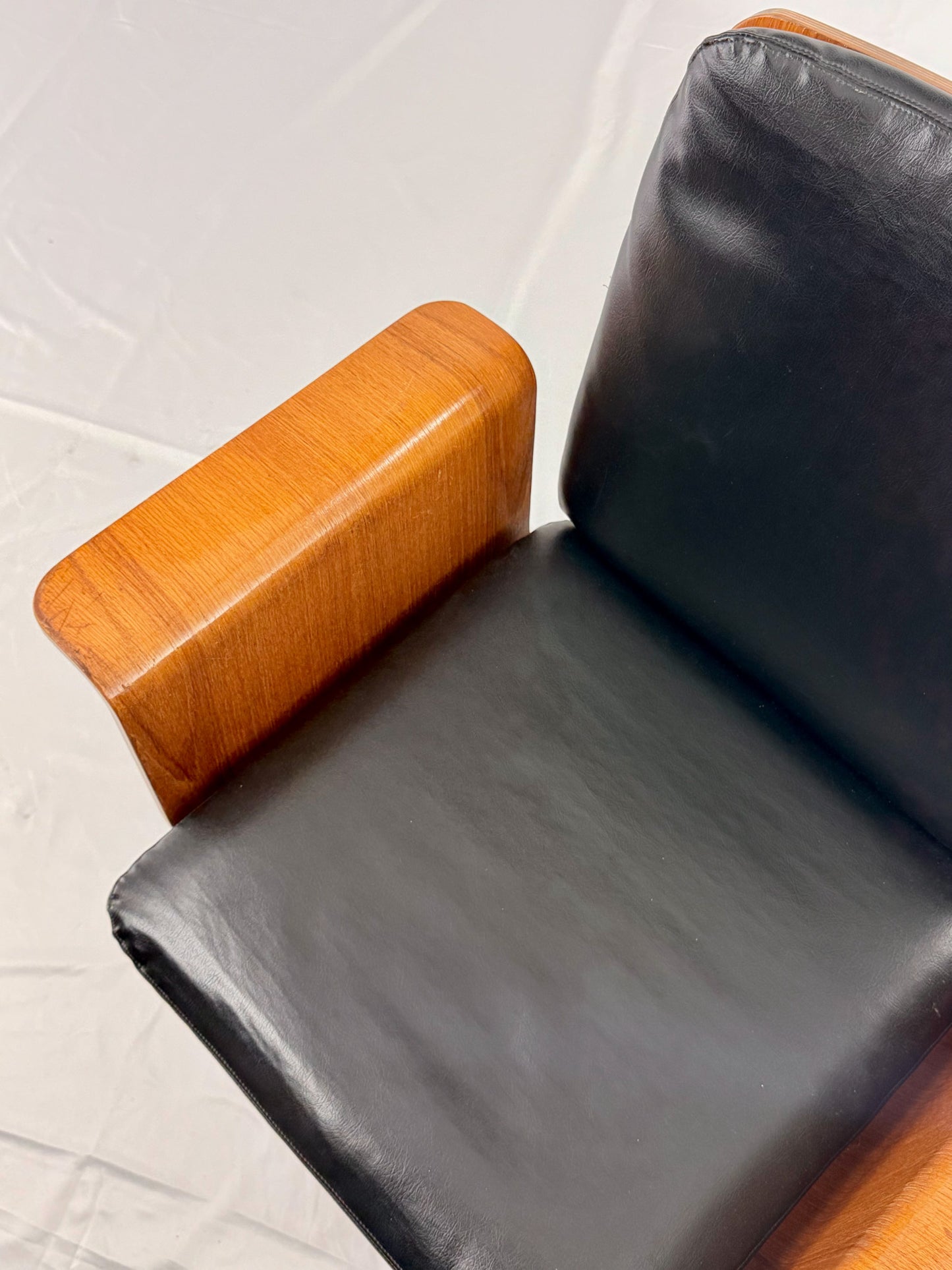 Mid Century Modern office chair with wooden frame and leather seat with a white background