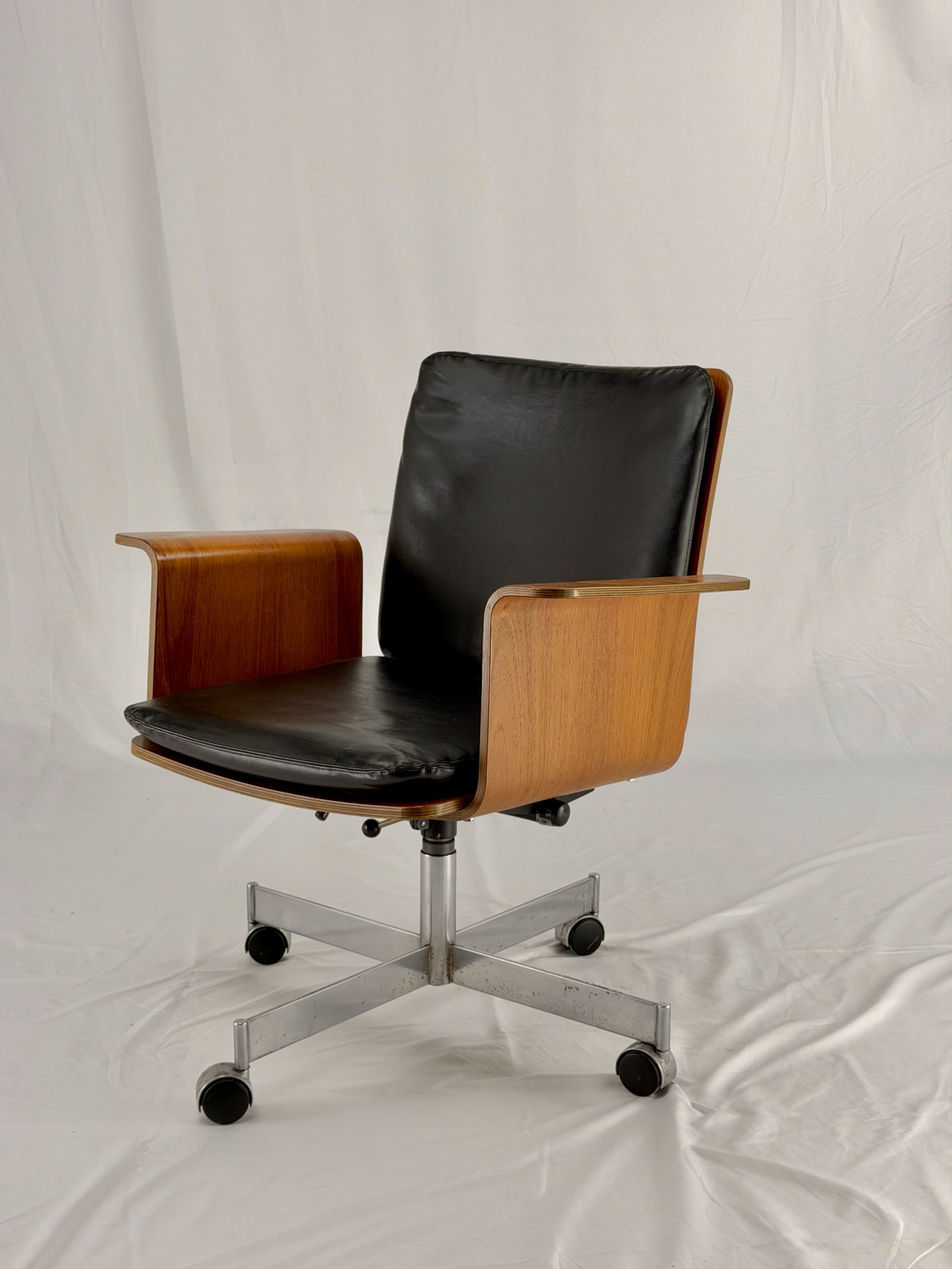 Mid Century Modern office chair with wooden frame and leather seat with a white background