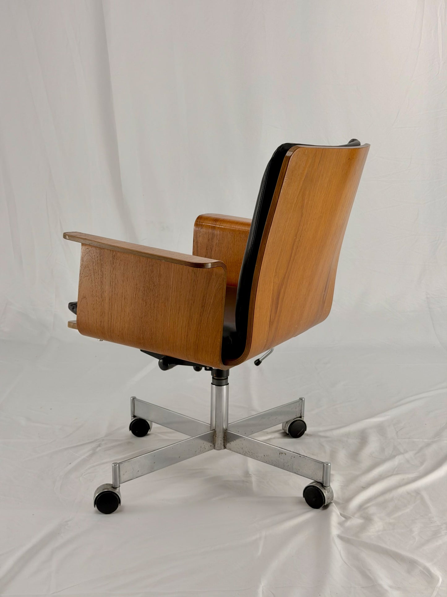 Mid Century Modern office chair with wooden frame and leather seat with a white background