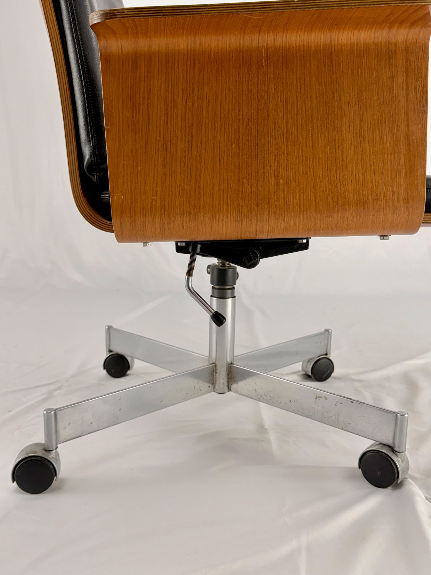 Mid Century Modern office chair with wooden frame and leather seat with a white background