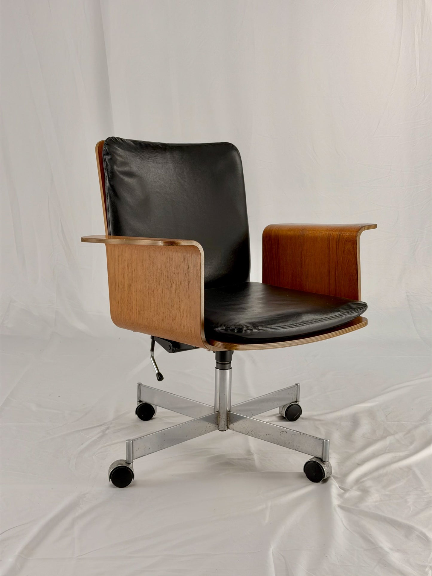 Mid Century Modern office chair with wooden frame and leather seat with a white background