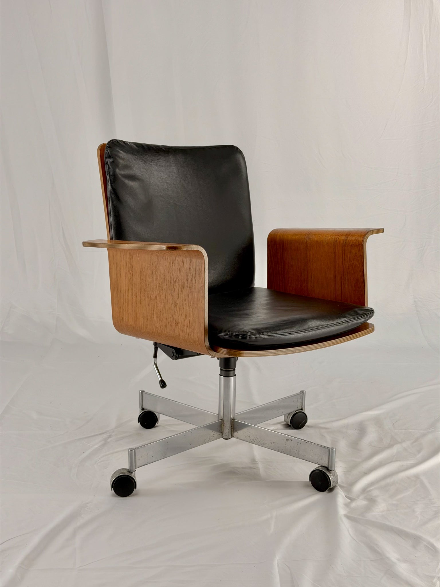 Mid Century Modern office chair with wooden frame and leather seat with a white background