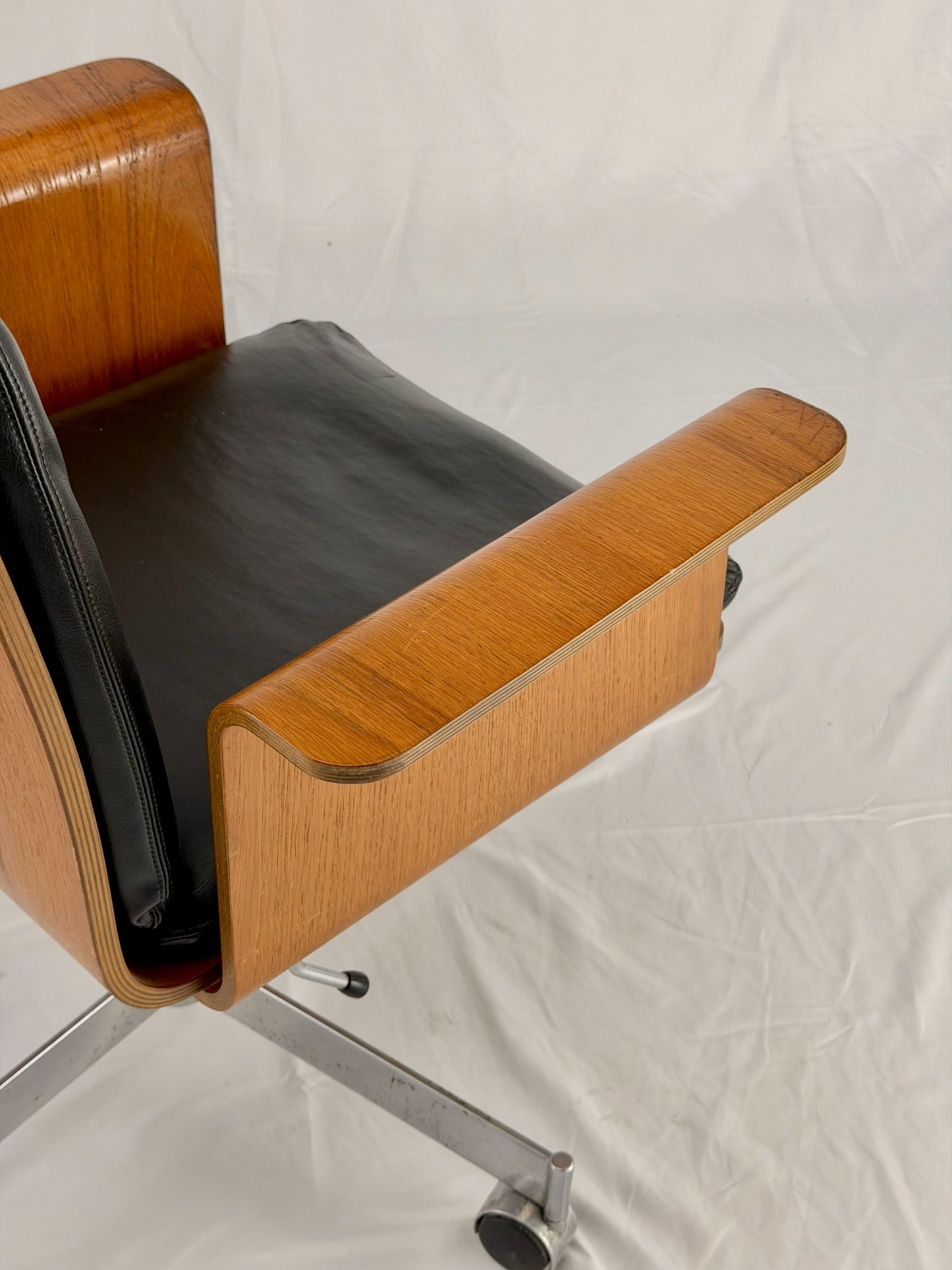 Mid Century Modern office chair with wooden frame and leather seat with a white background