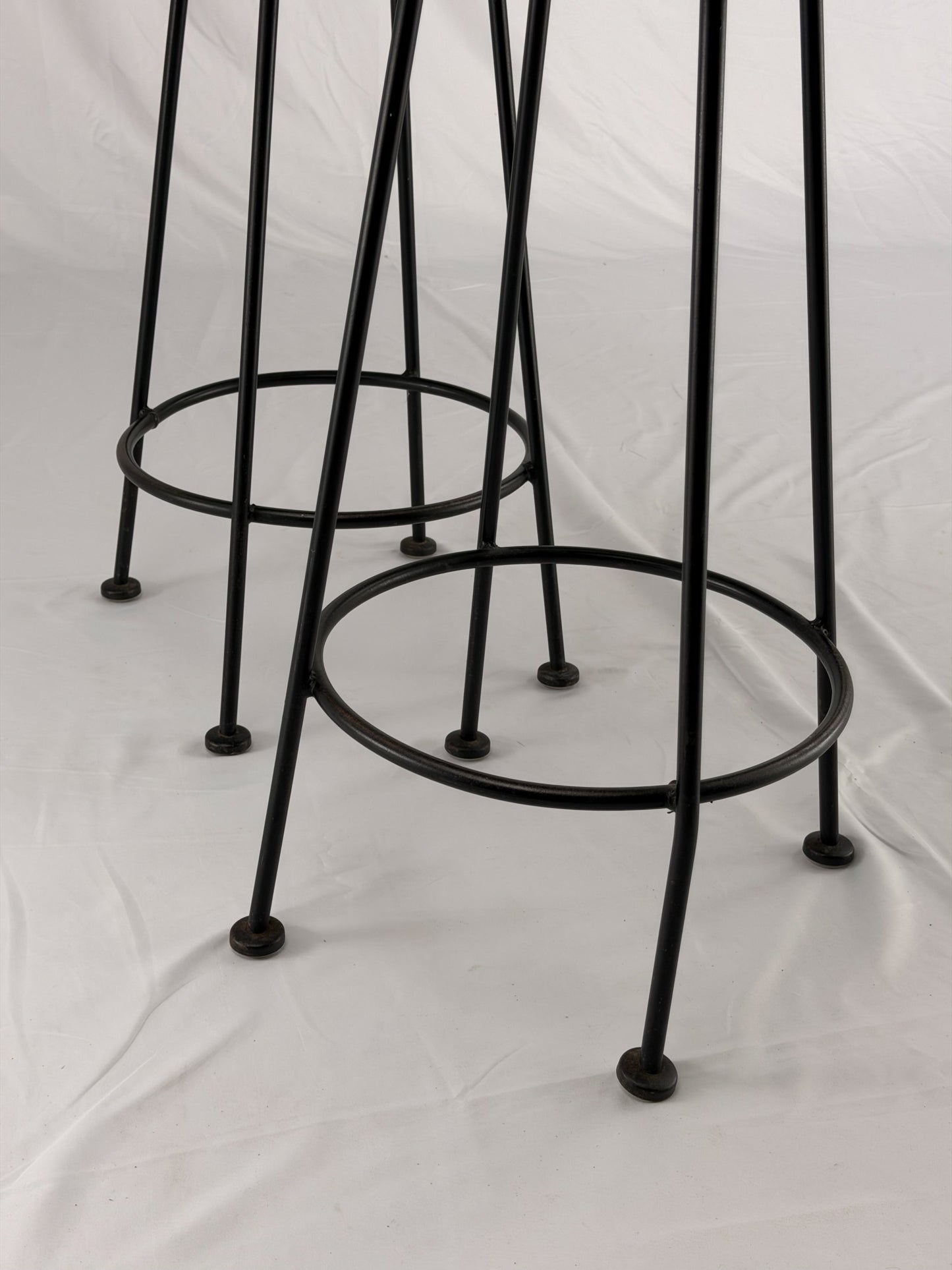 Two teal bar stools with black metal legs on a white background