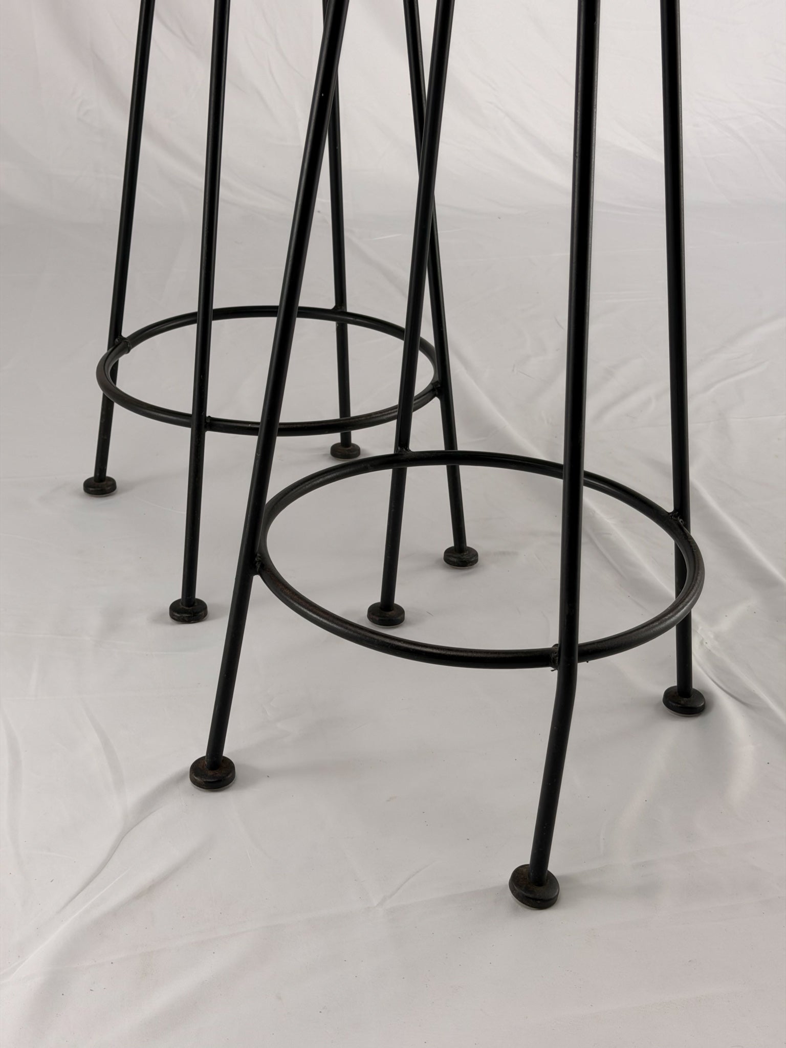 Two teal bar stools with black metal legs on a white background