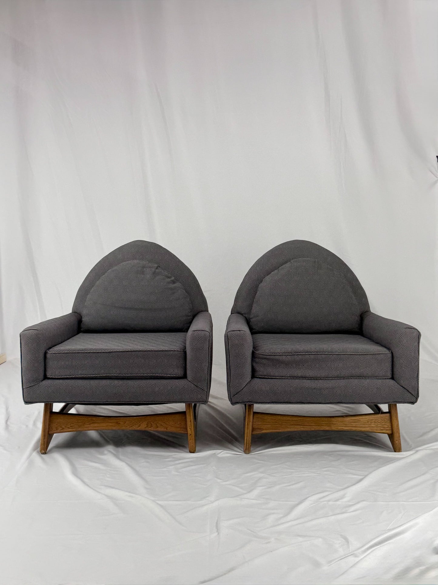 Two gray armchairs with wooden legs on a white background