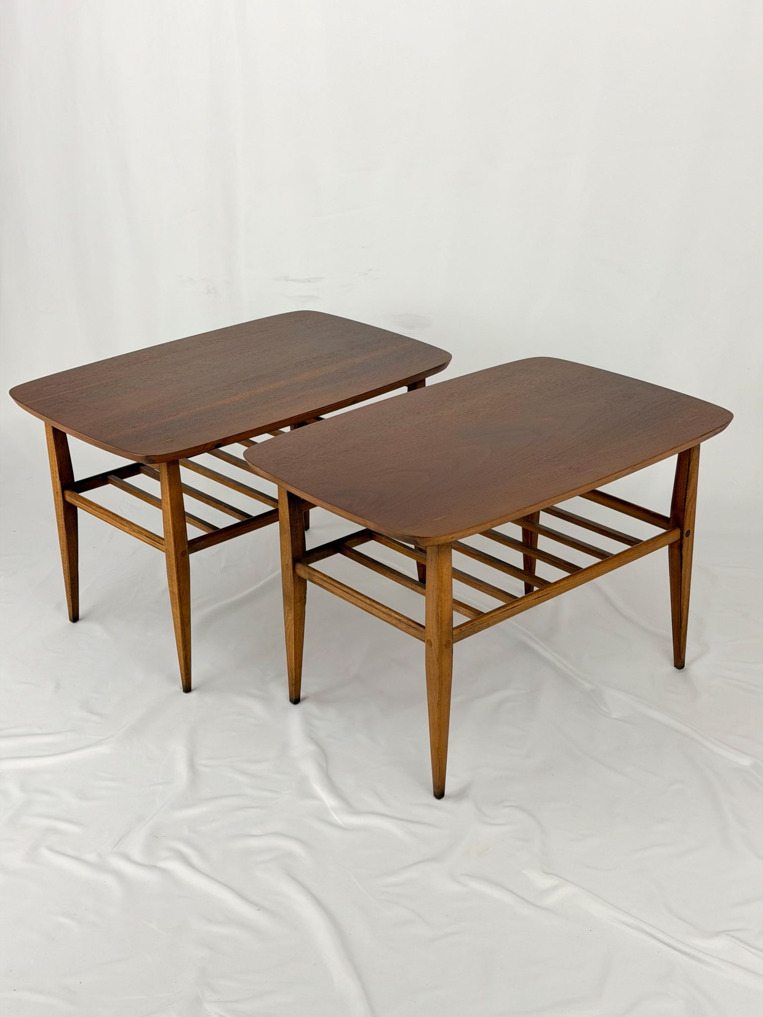 Two wooden side tables on a white background