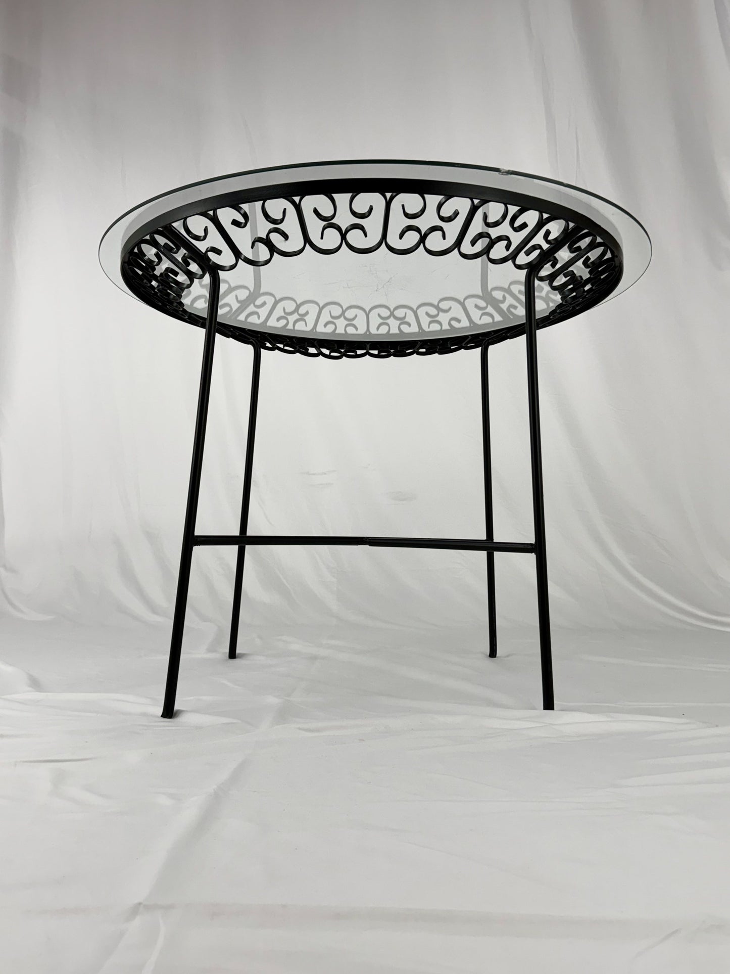 Round metal table with intricate design on a white background