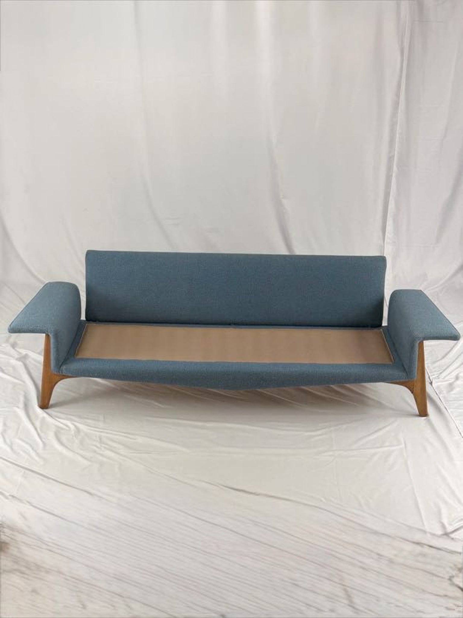 Blue sofa with wooden legs on a white background