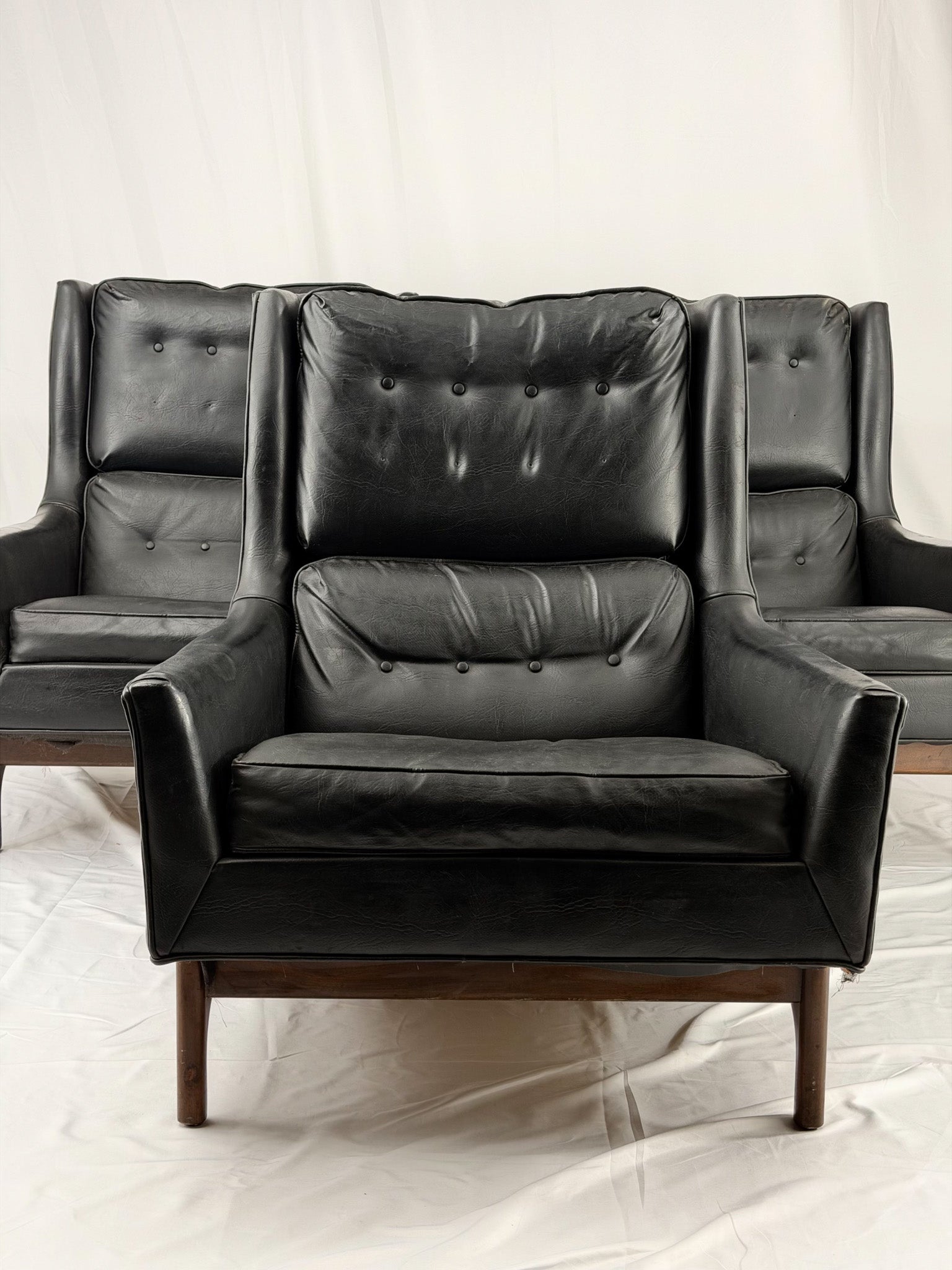 Black leather armchair with tufted backrest on a white background