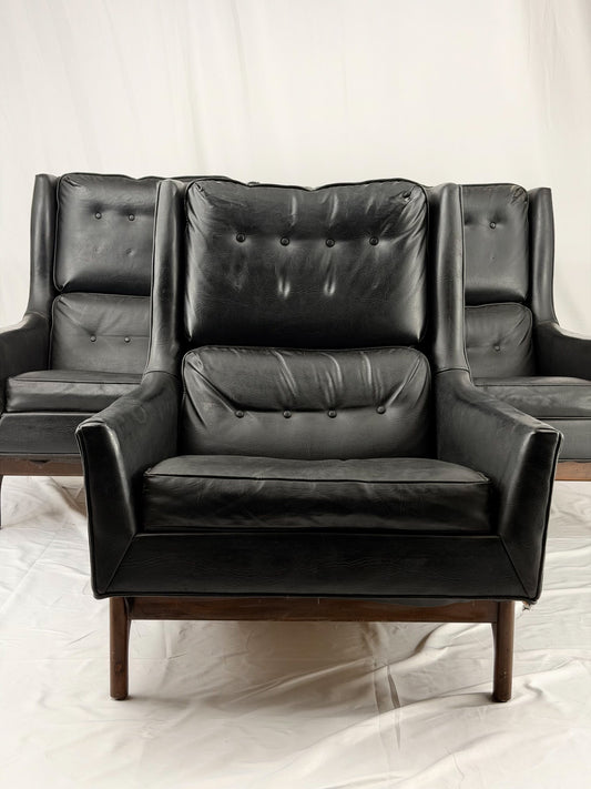 Black leather armchair with tufted backrest on a white background