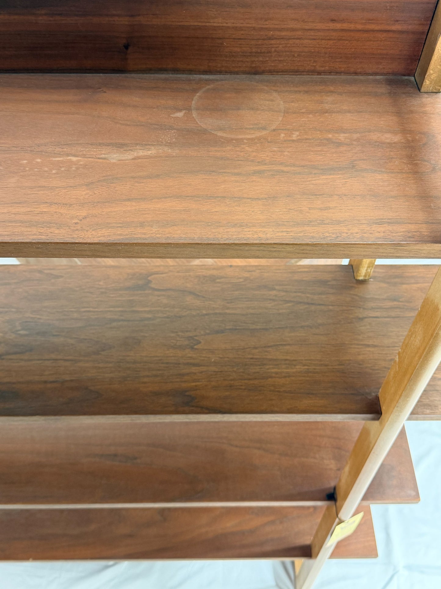 Wooden shelf unit with multiple shelves and drawers on a white background