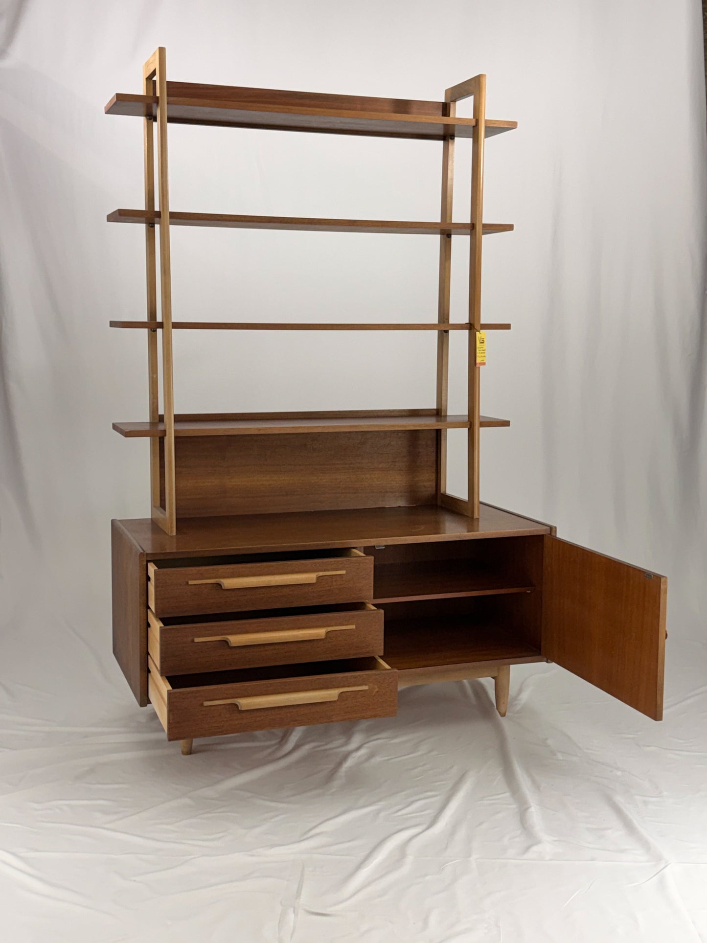 Wooden shelf unit with multiple shelves and drawers on a white background