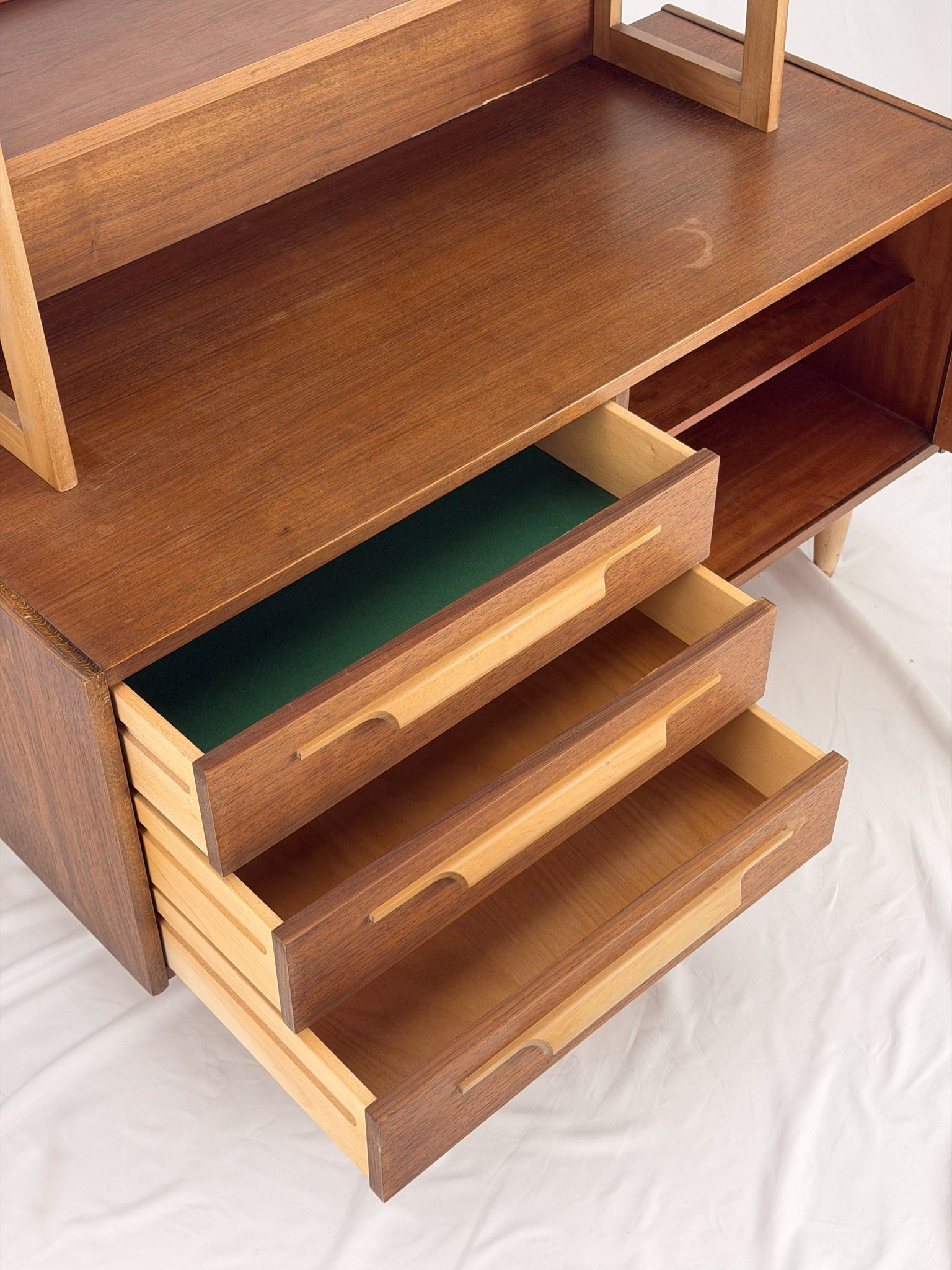 Wooden shelf unit with multiple shelves and drawers on a white background