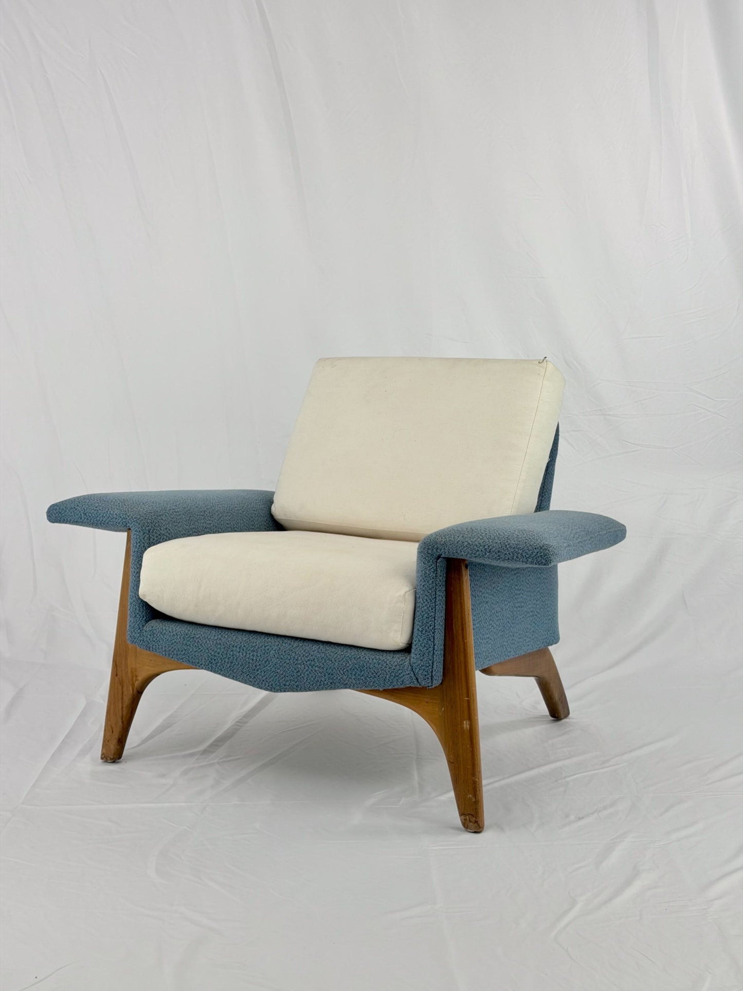 Modern armchair with blue and beige cushions on a white background