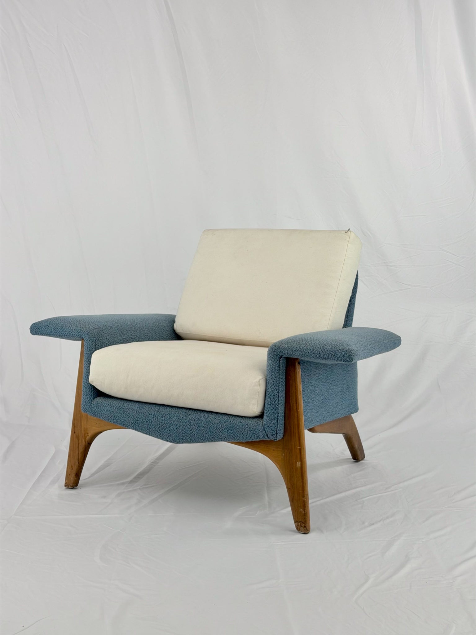 Modern armchair with blue and beige cushions on a white background