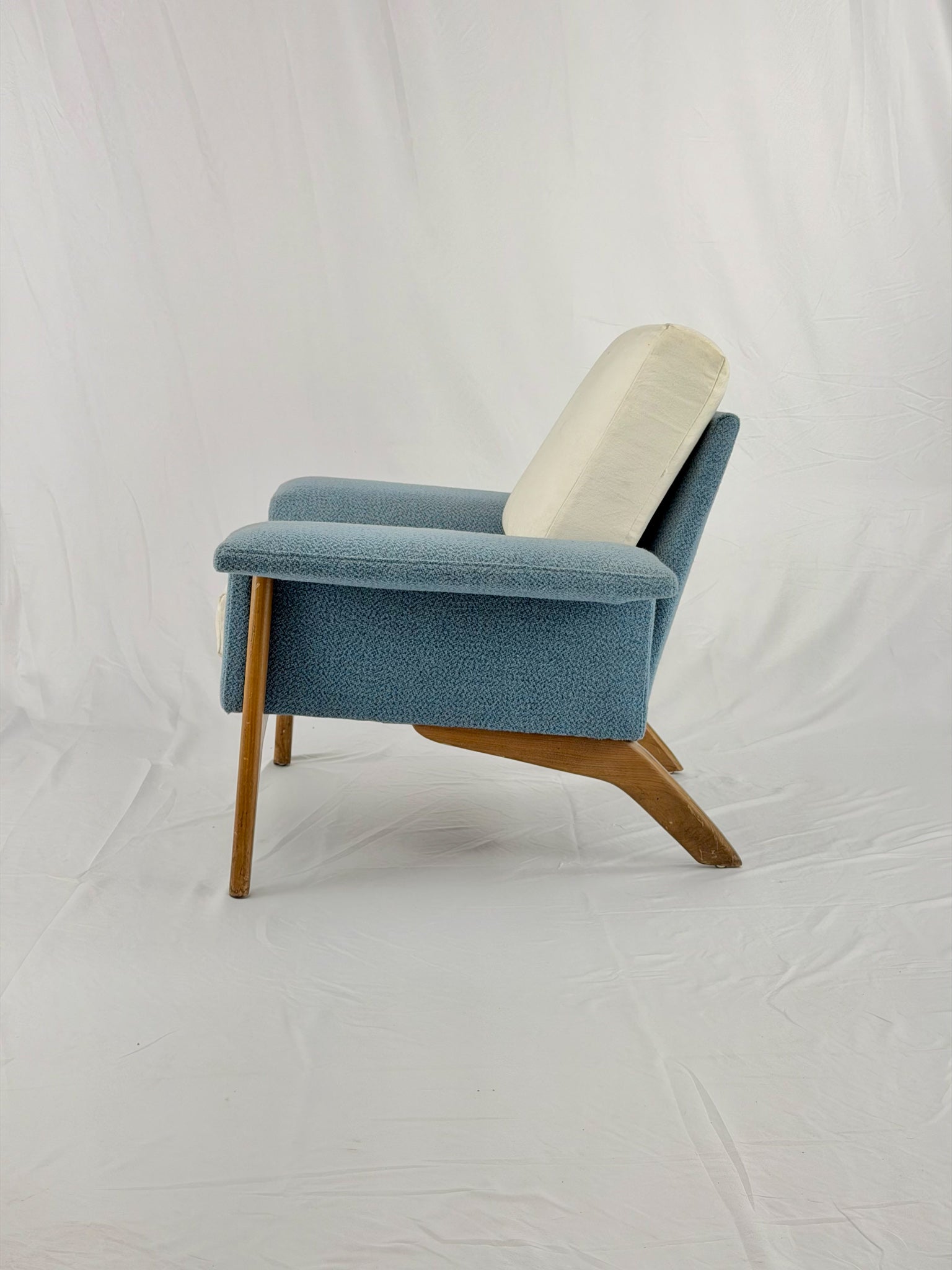 Blue armchair with wooden legs on a white background
