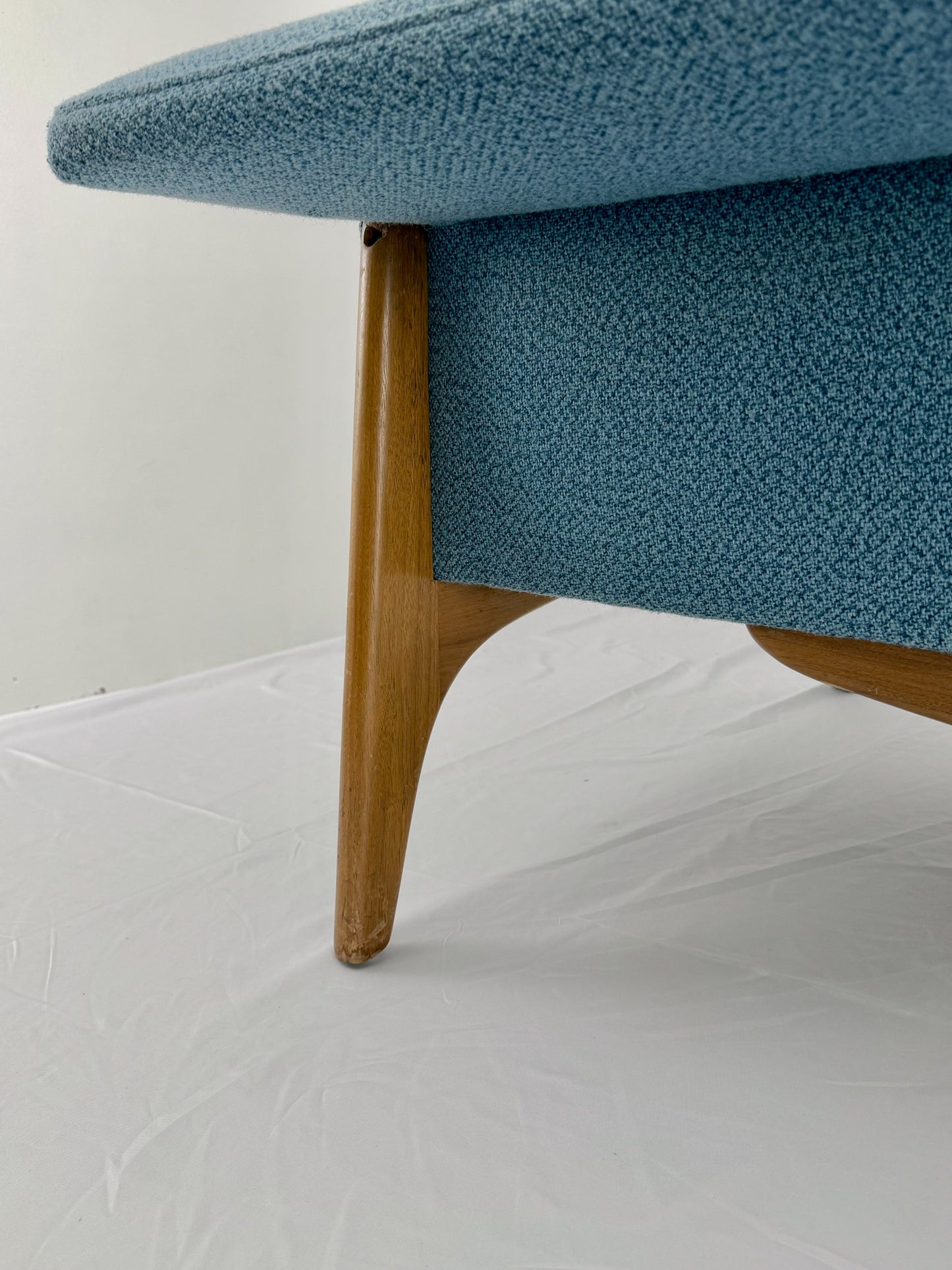 Armchair with blue upholstery and wooden legs on a white background