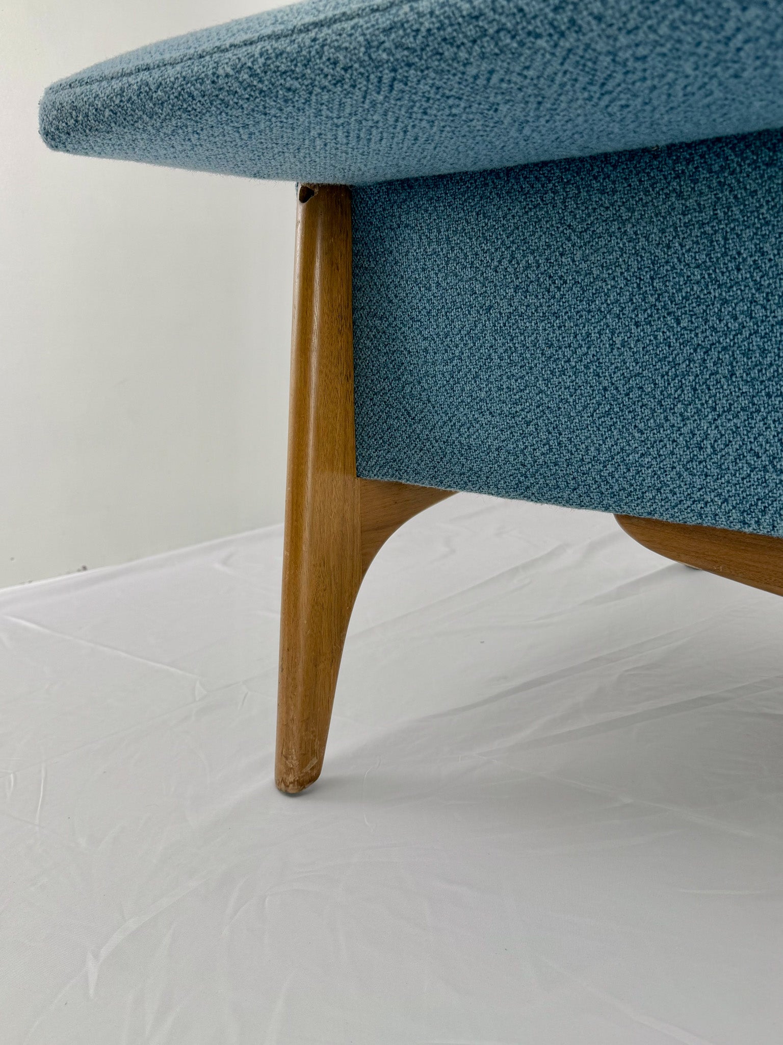 Armchair with blue upholstery and wooden legs on a white background