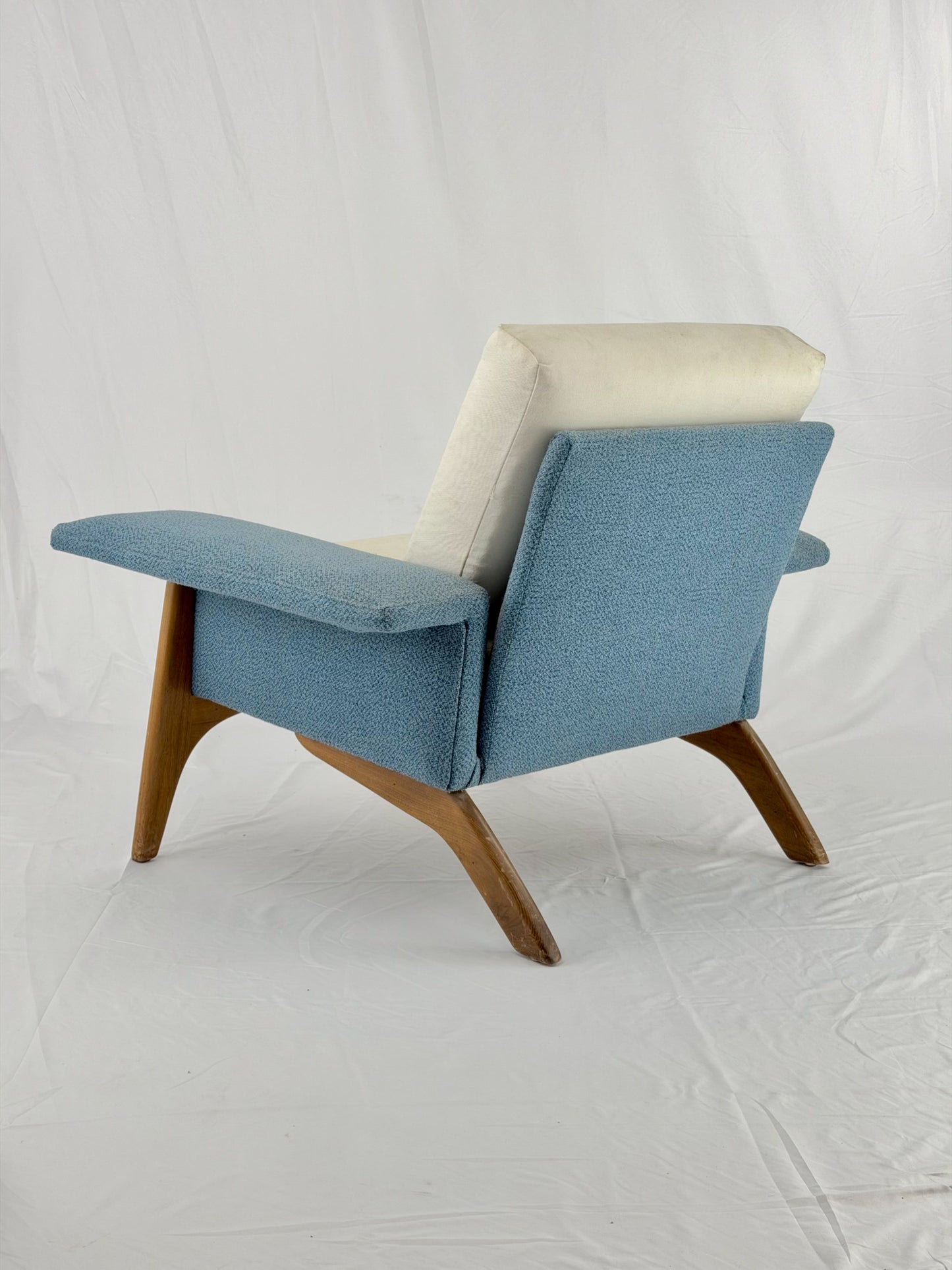 Blue armchair with wooden legs on a white background