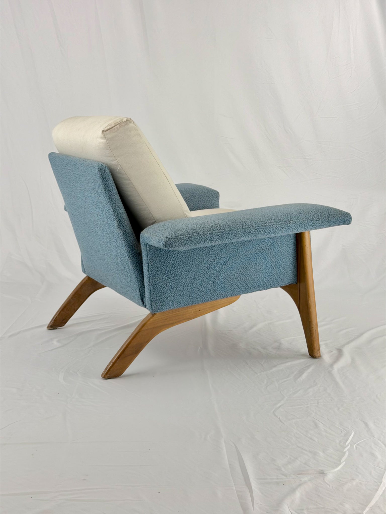 Blue armchair with wooden legs on a white background