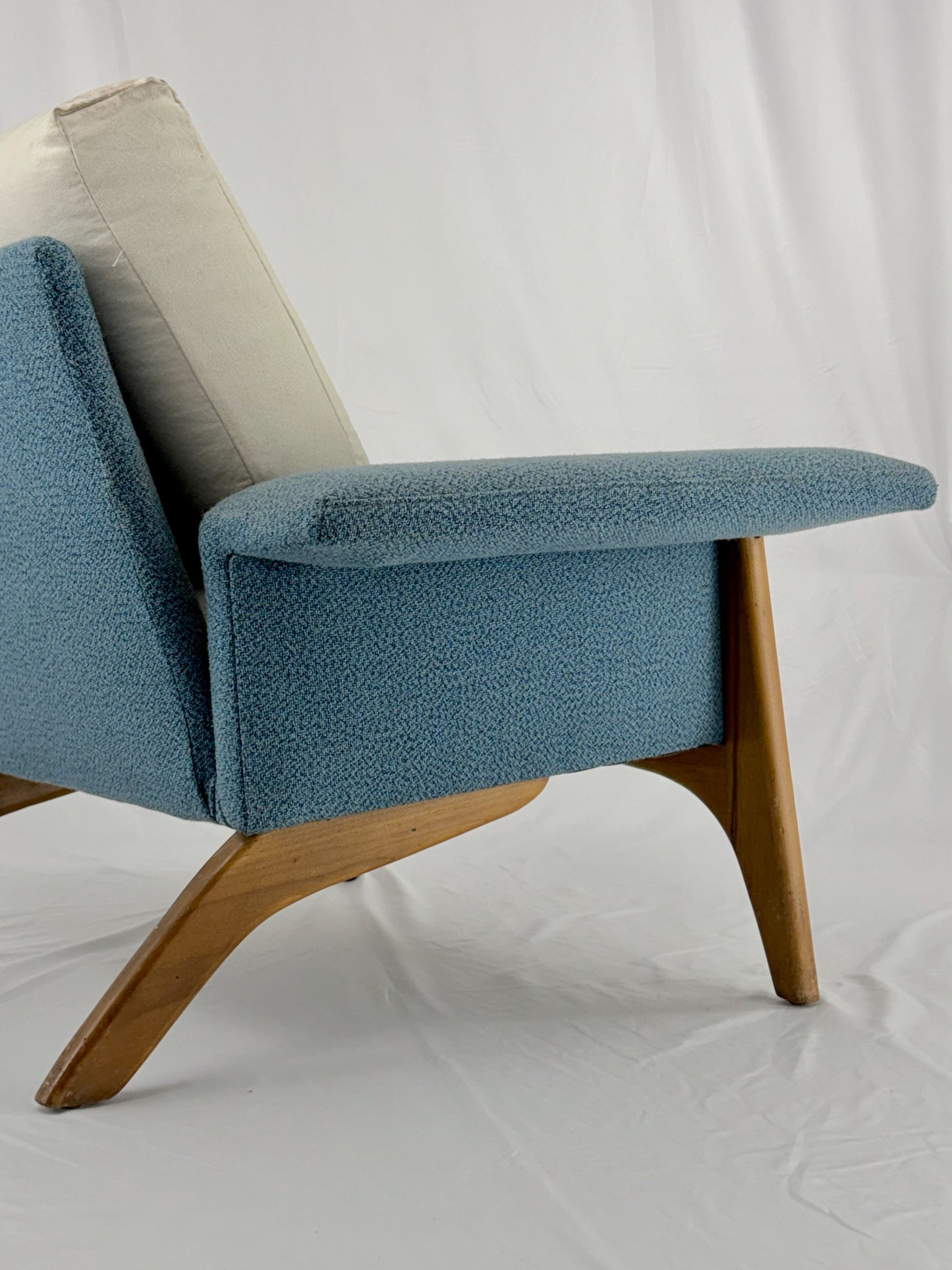 Blue armchair with wooden legs on a white background