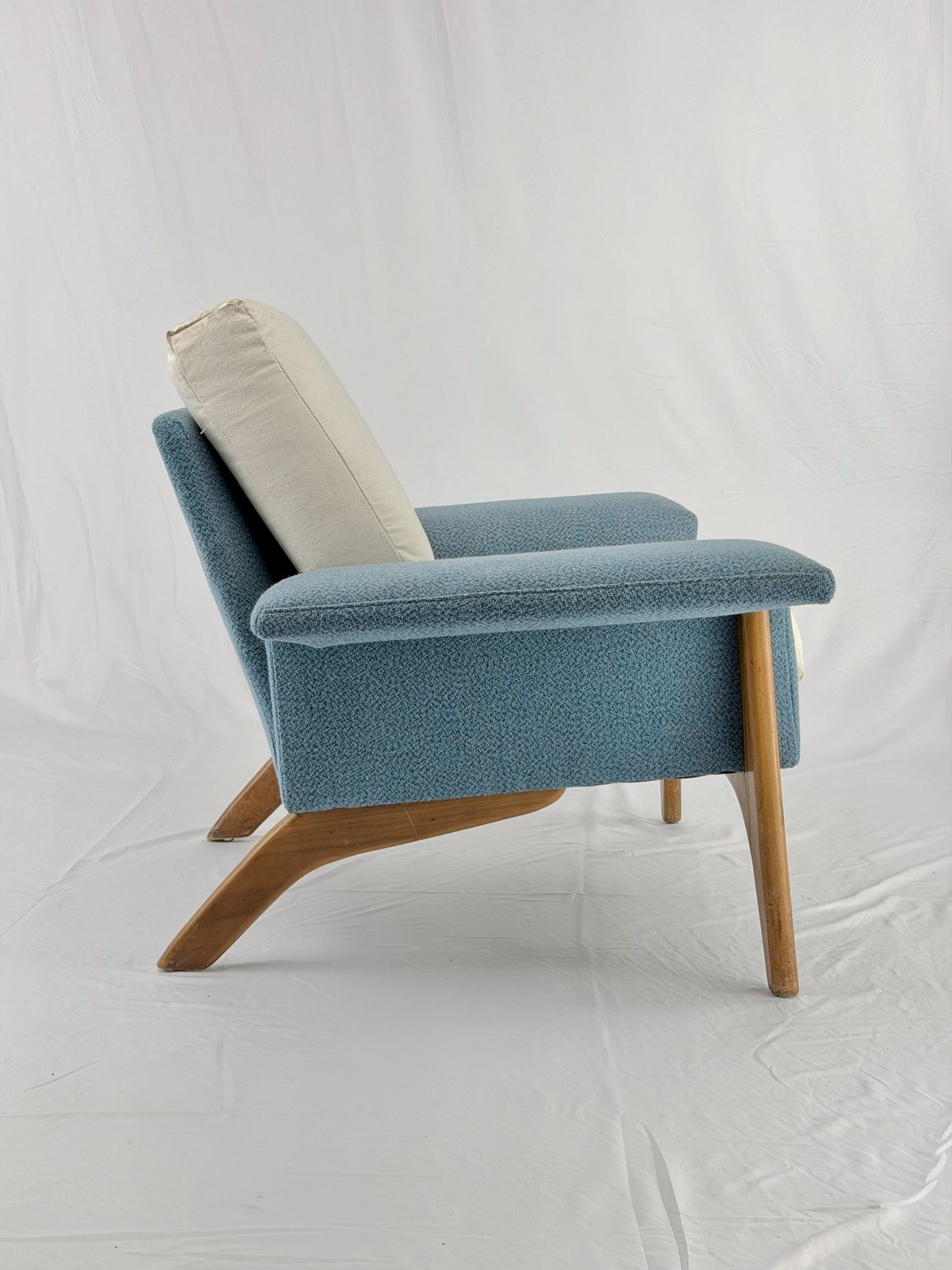 Blue armchair with wooden legs on a white background