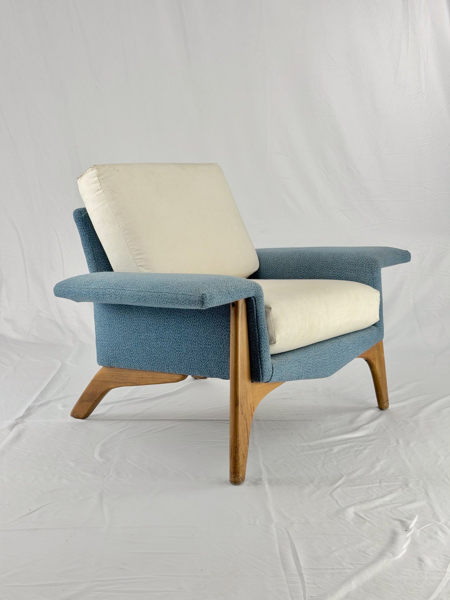 Blue armchair with beige cushion on a white background