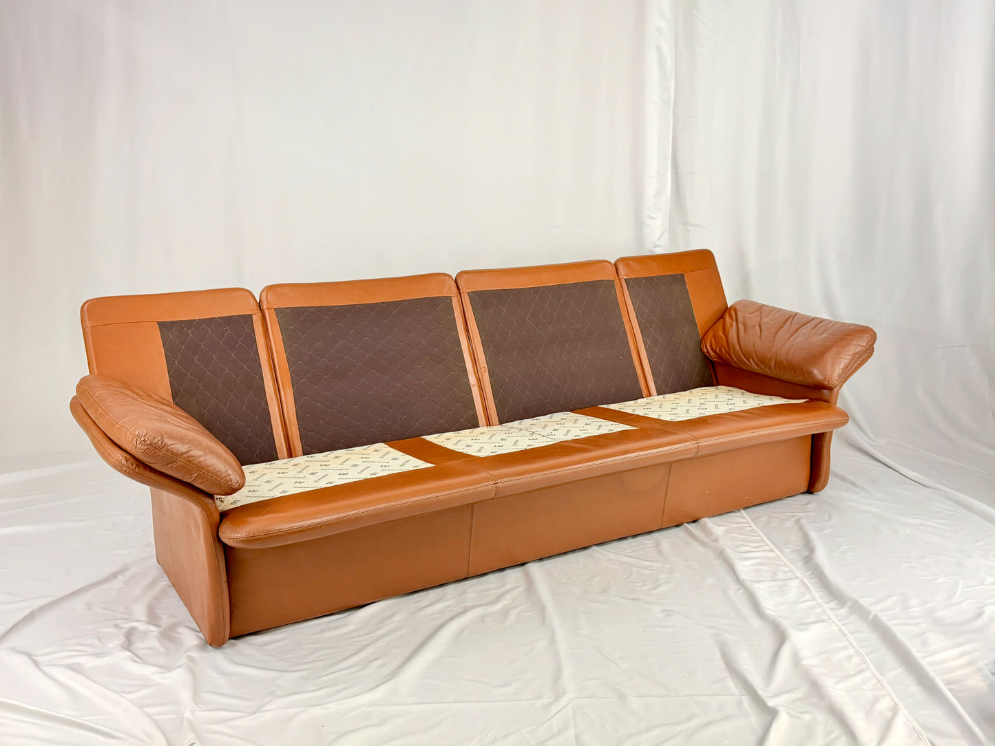 Brown leather sofa with brown cushions on a white background