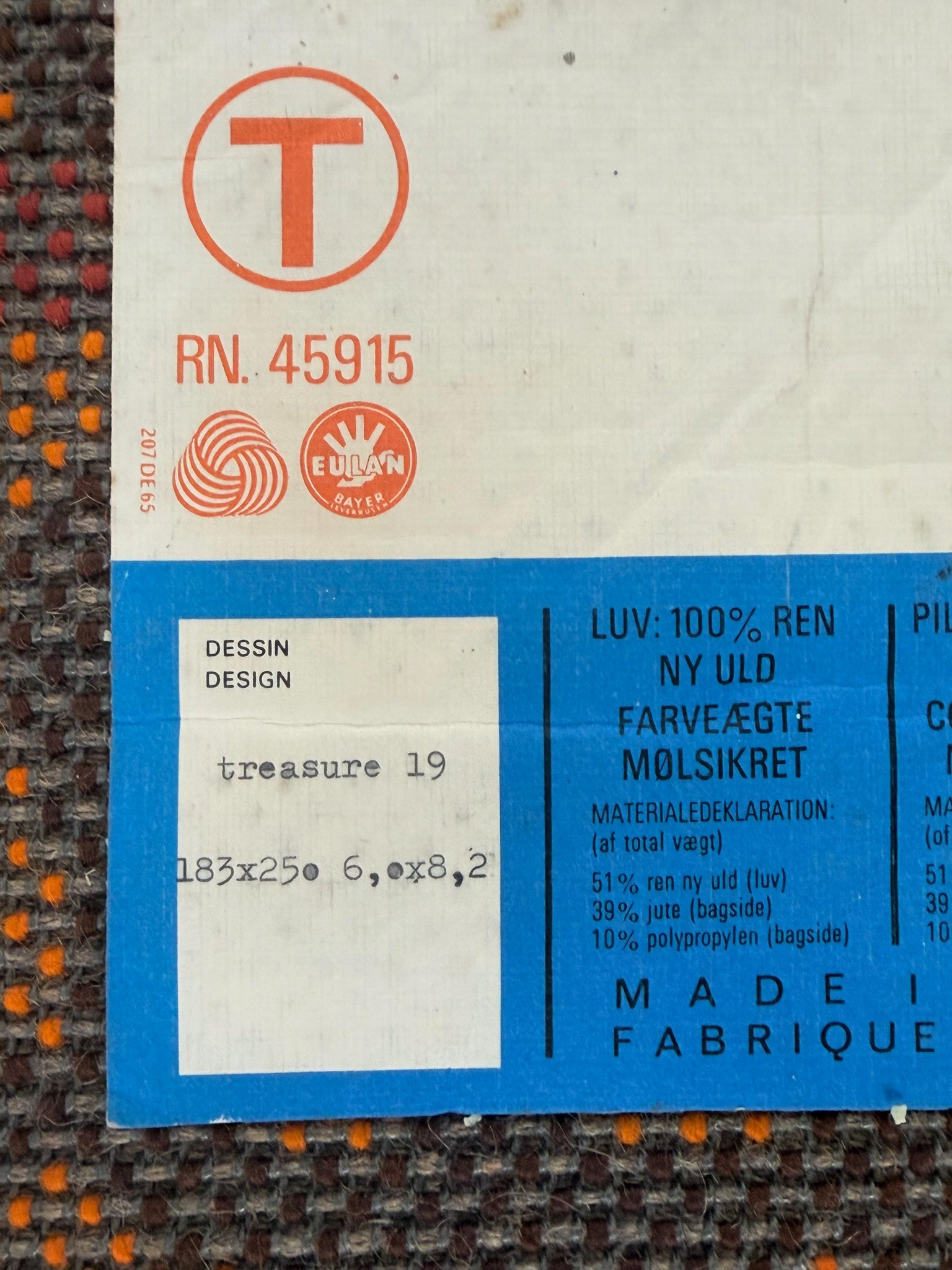 Fabric label with text and logos on a textured fabric background