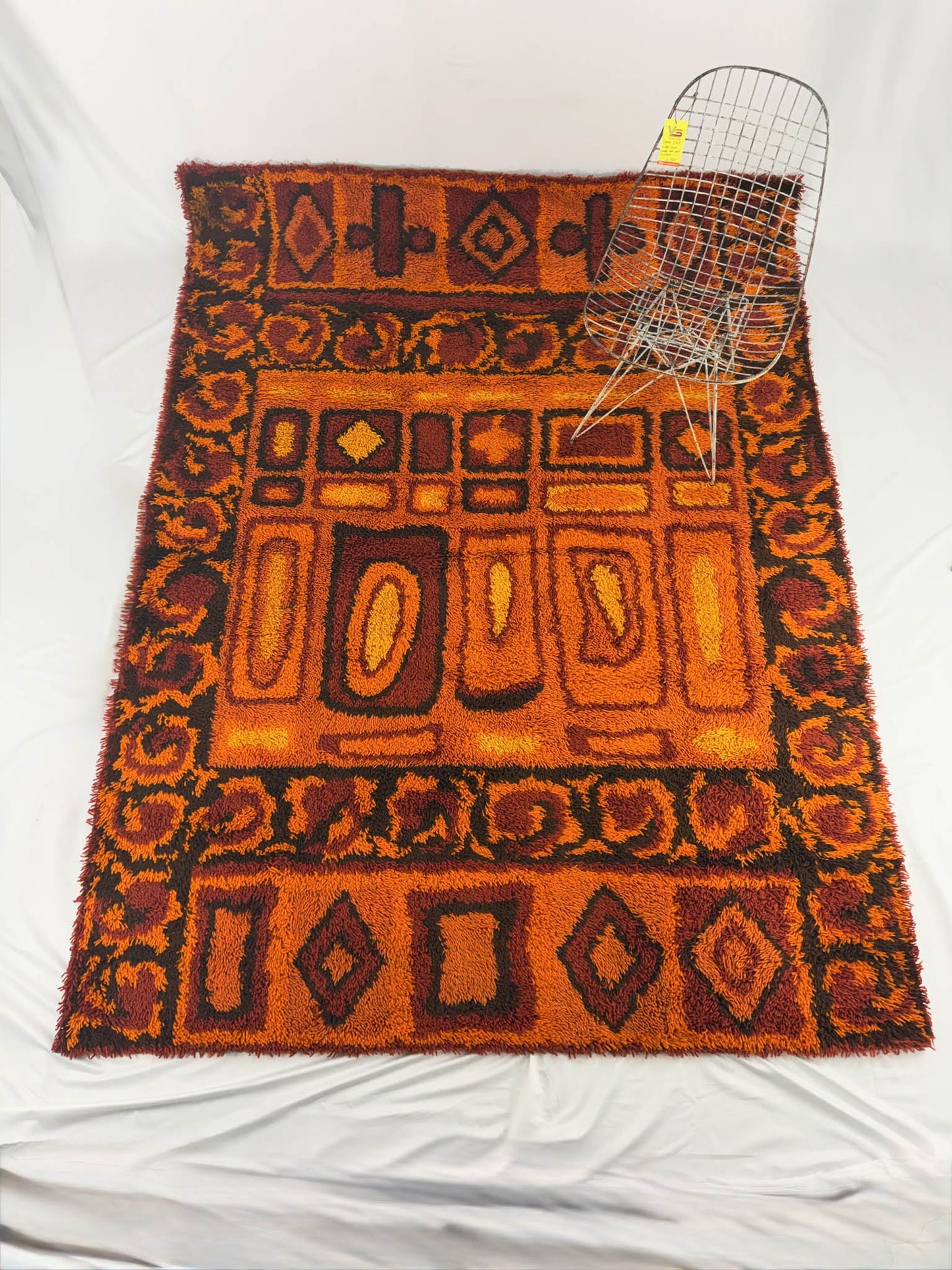 Rya shag rug with warm toned geometric pattern on a white background