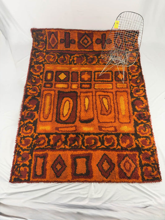Rya shag rug with warm toned geometric pattern on a white background