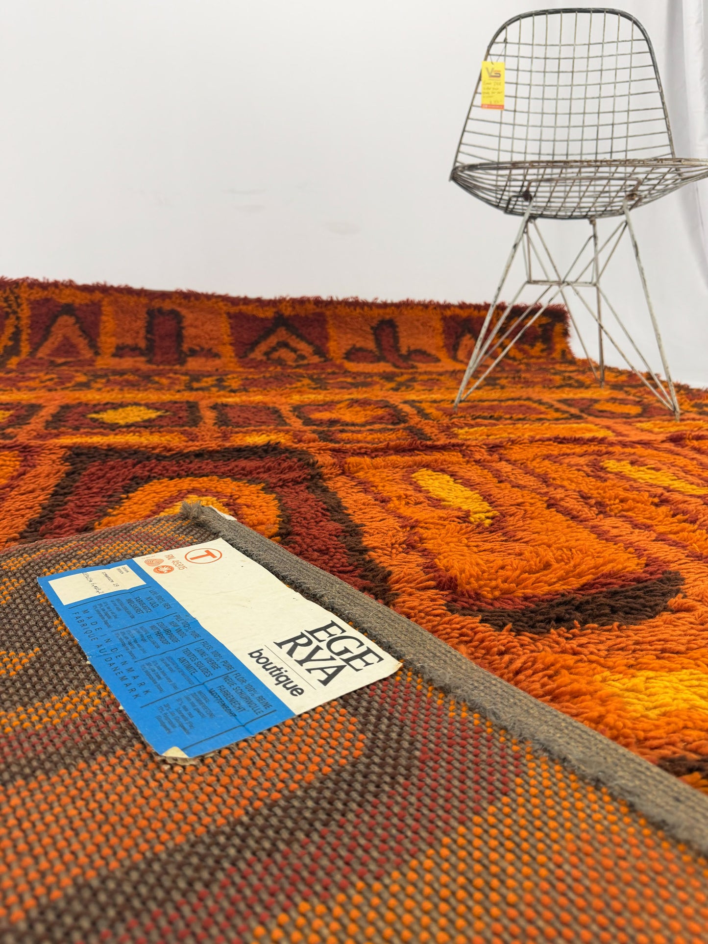 Rya shag rug with warm toned geometric pattern on a white background